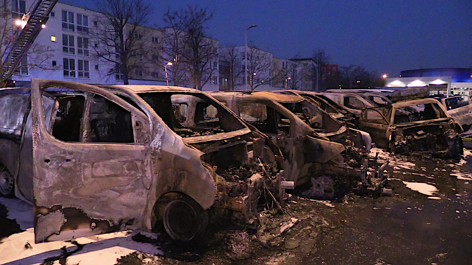 Ausgebrannte Kleintransporter stehen an einem Autohaus im Berliner Bezirk Marzahn-Hellersdorf.&nbsp;
