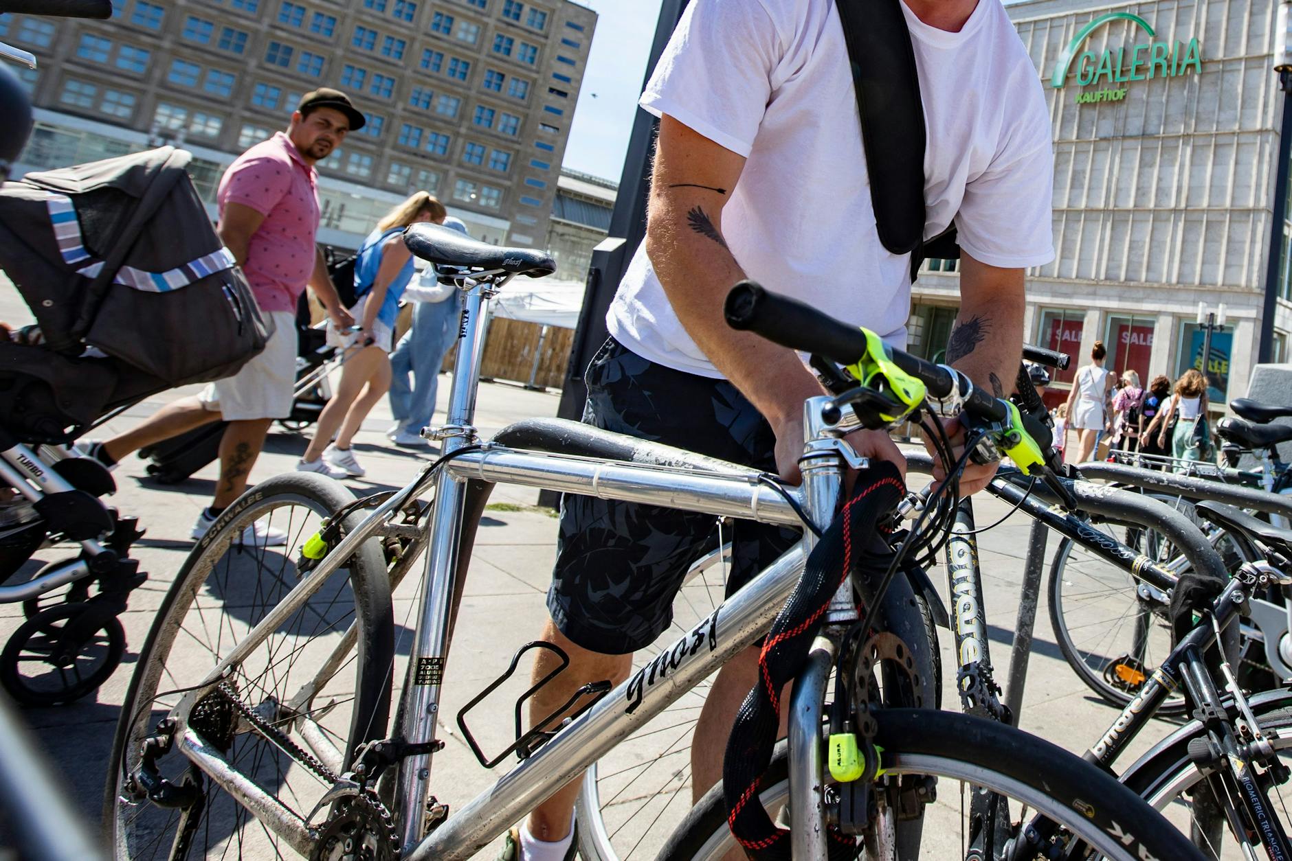 Ein Mann kettet sein Fahrrad am Alexanderplatz in Berlin an. 
