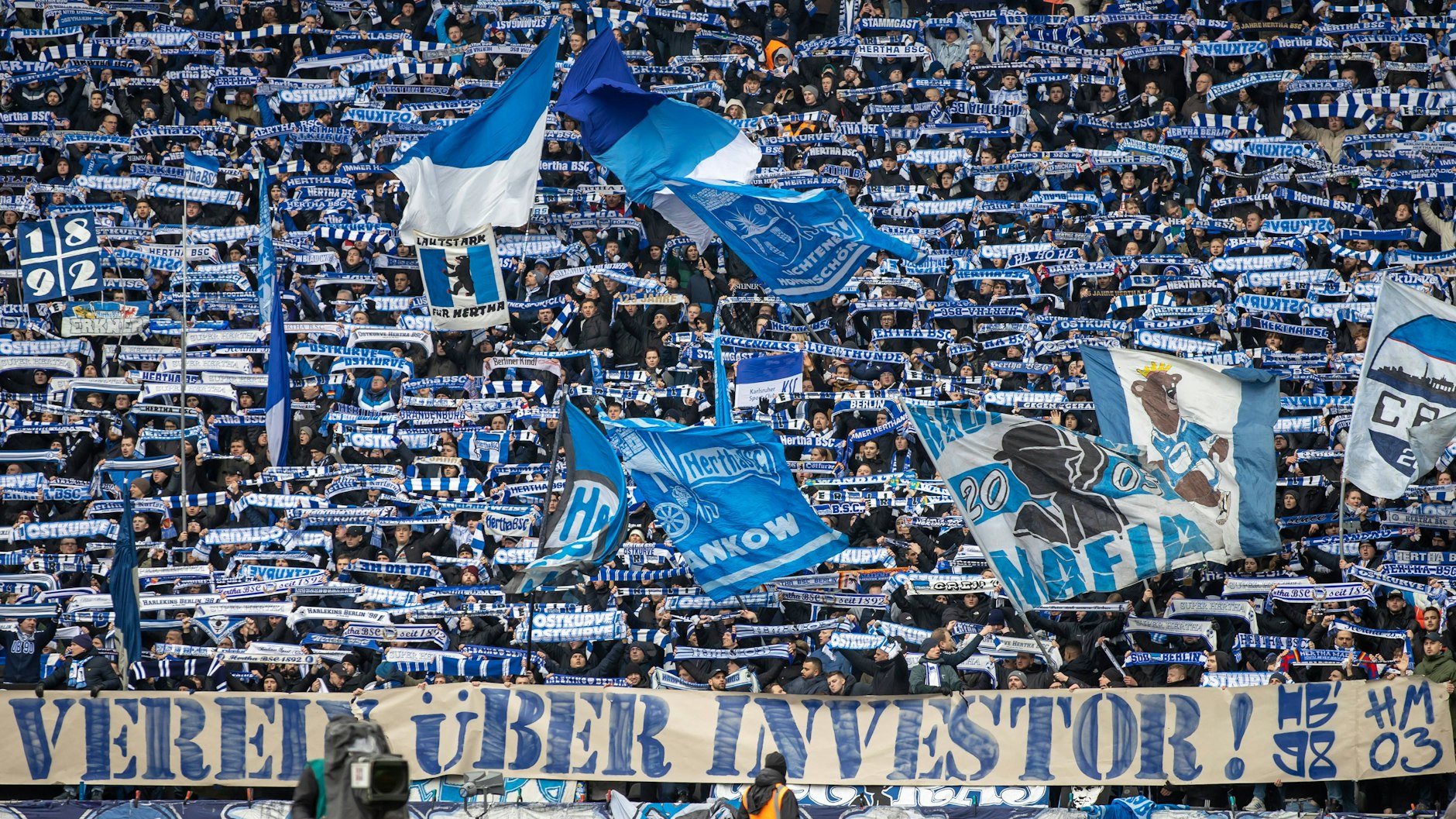 Fans von Hertha BSC feuern ihre Mannschaft an und positionieren sich gegen einen Investor.
