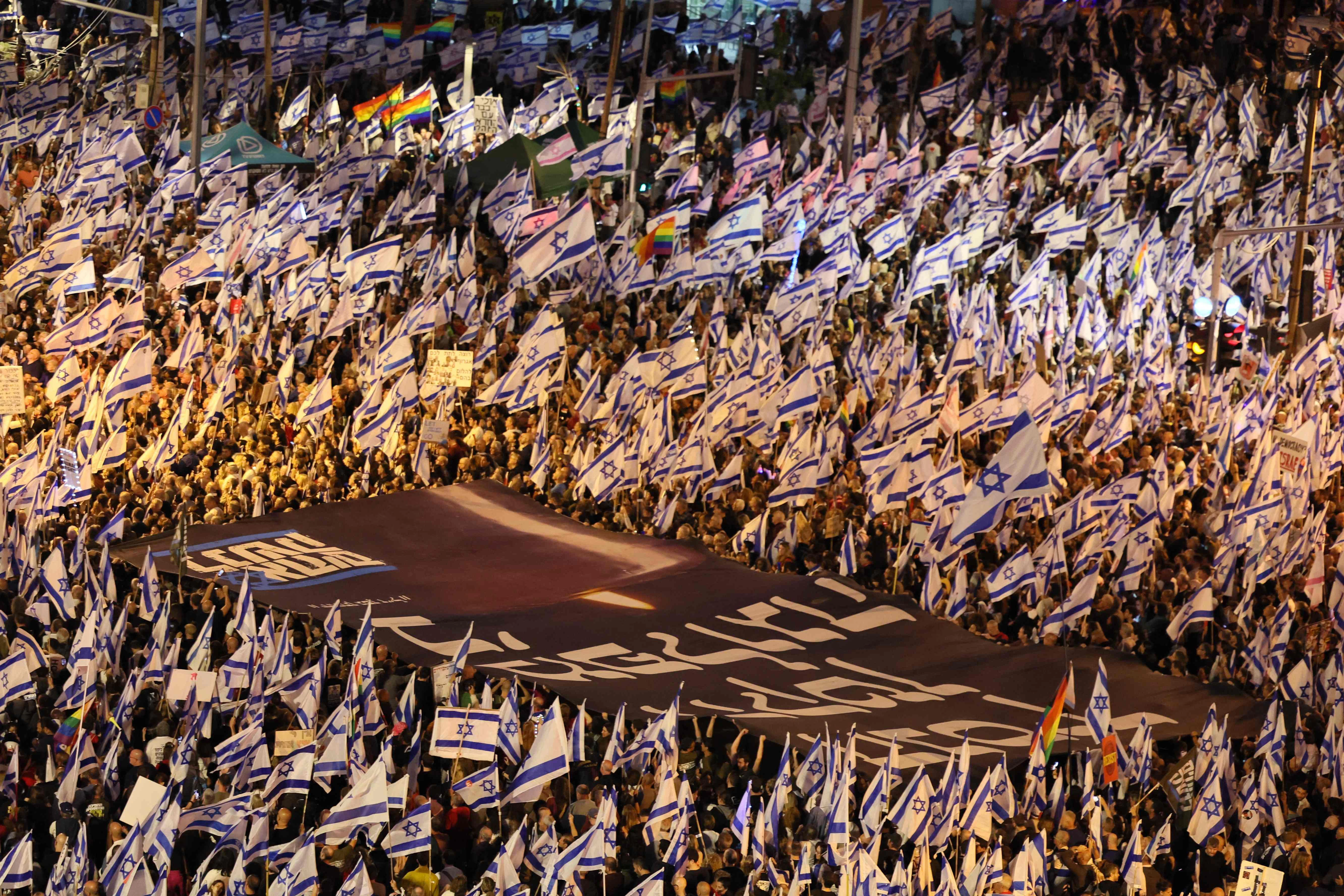 Tausende israelische Flagge, dazwischen Regenbogenflaggen, auf den Straßen und Plätzen in Tel Aviv.