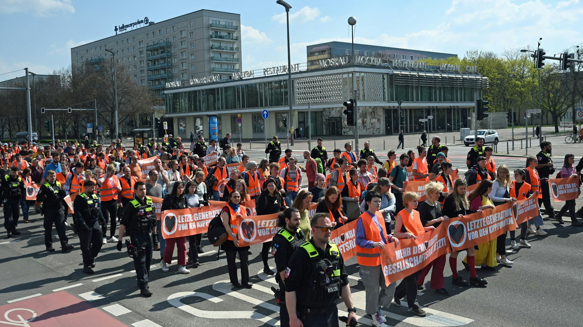 Die Gruppe „Letzte Generation“ protestiert mit einer Demonstration auf der Karl-Marx-Allee in Berlin-Friedrichshain. Mit solchen Schleichmärschen wollen die Klima-Kleber auch in den kommenden Tagen den Verkehr auf den Hauptstraßen ausbremsen.