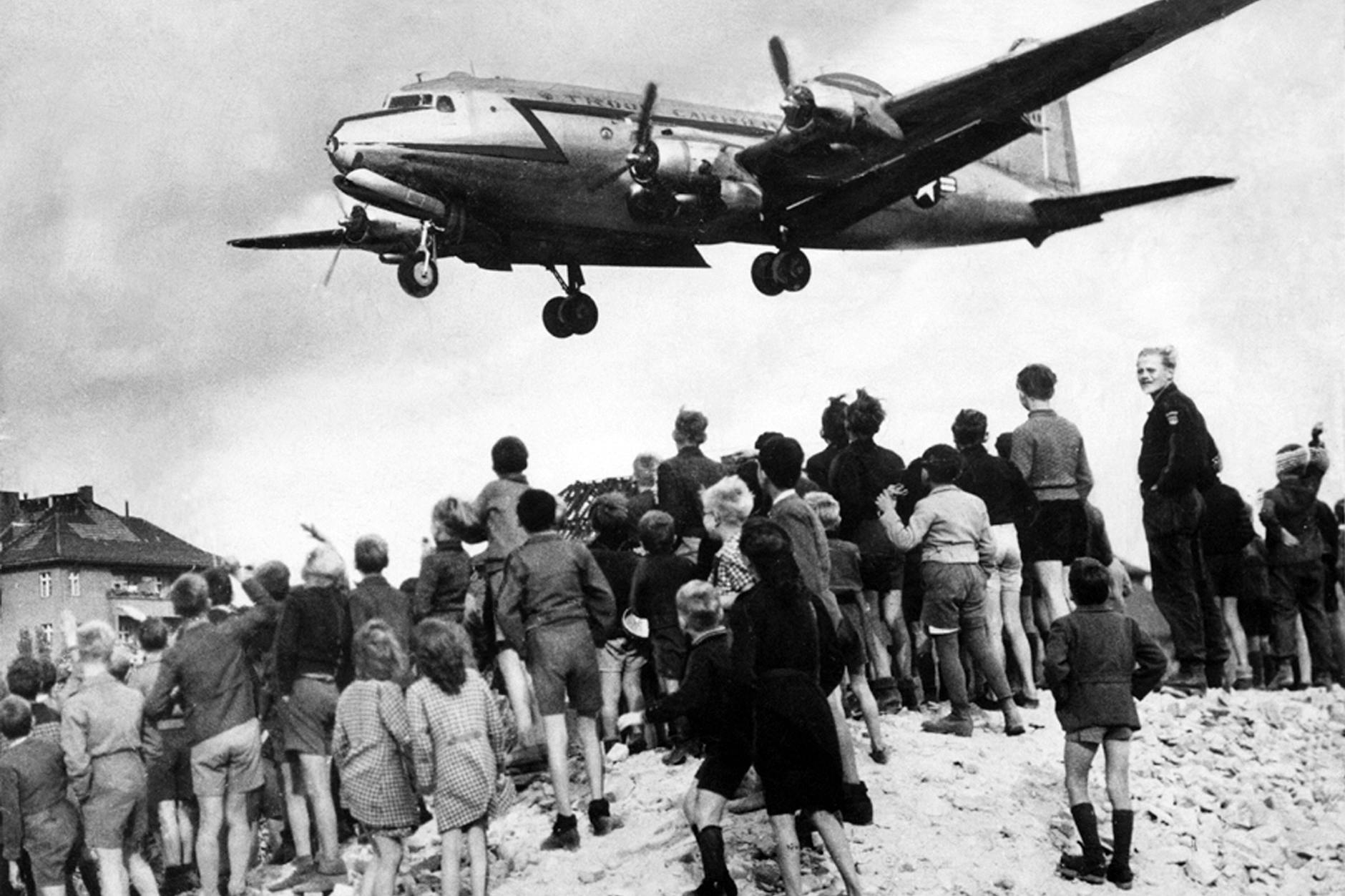 Alles Gute kommt von oben: Kinder und Jugendliche verfolgen im Sommer 1948 den Anflug eines amerikanischen Transportflugzeugs auf Tempelhof. Die Luftbrücke, eine Folge der Blockade West-Berlins durch die Sowjetunion, dauerte 322 Tage.