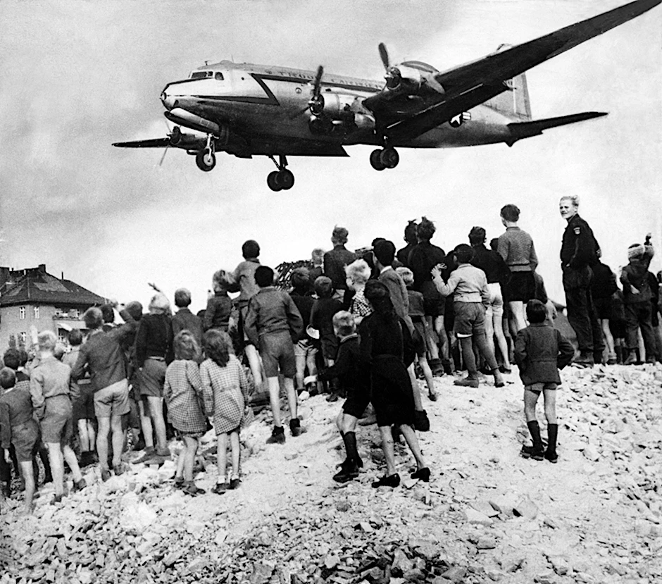 Alles Gute kommt von oben: Kinder und Jugendliche verfolgen im Sommer 1948 den Anflug eines amerikanischen Transportflugzeugs auf Tempelhof. Die Luftbrücke, eine Folge der Blockade West-Berlins durch die Sowjetunion, dauerte 322 Tage.