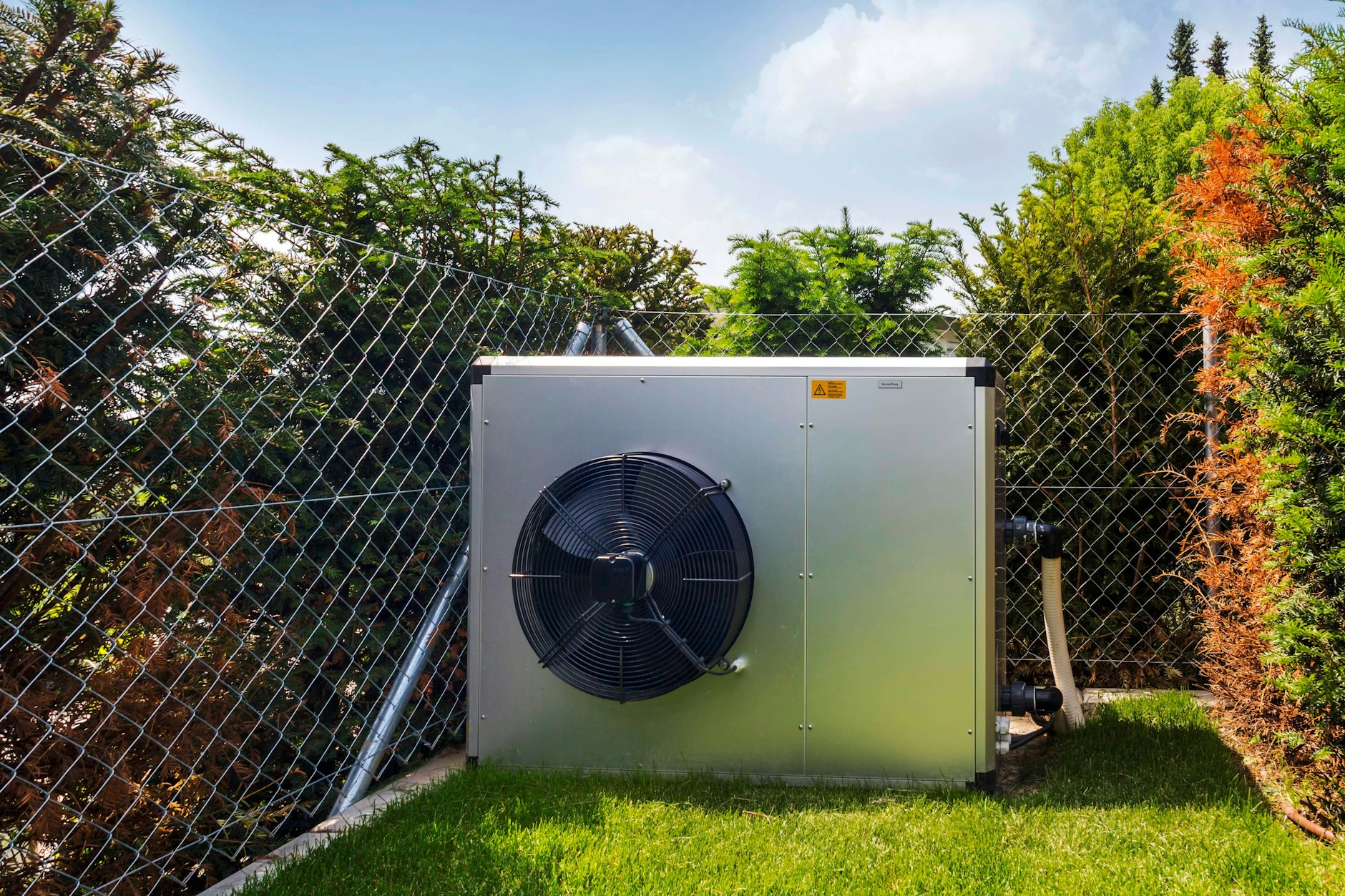 Eine Wärmepumpe steht in einem Vorgarten.