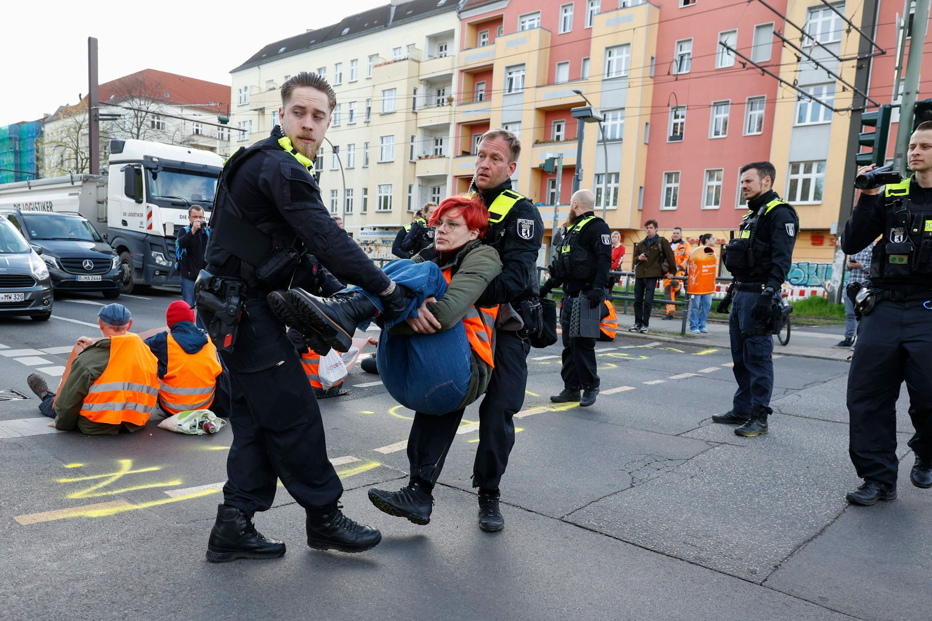 Polizisten tragen eine Aktivistin der Letzen Generation von der Danziger Straße weg.&nbsp;