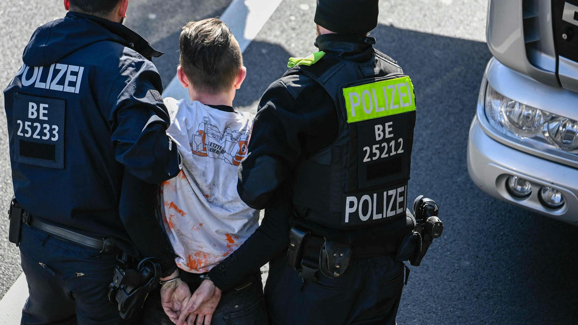 Auf der A100: Die Polizei führt in Handschellen einen Klima-Kleber ab.