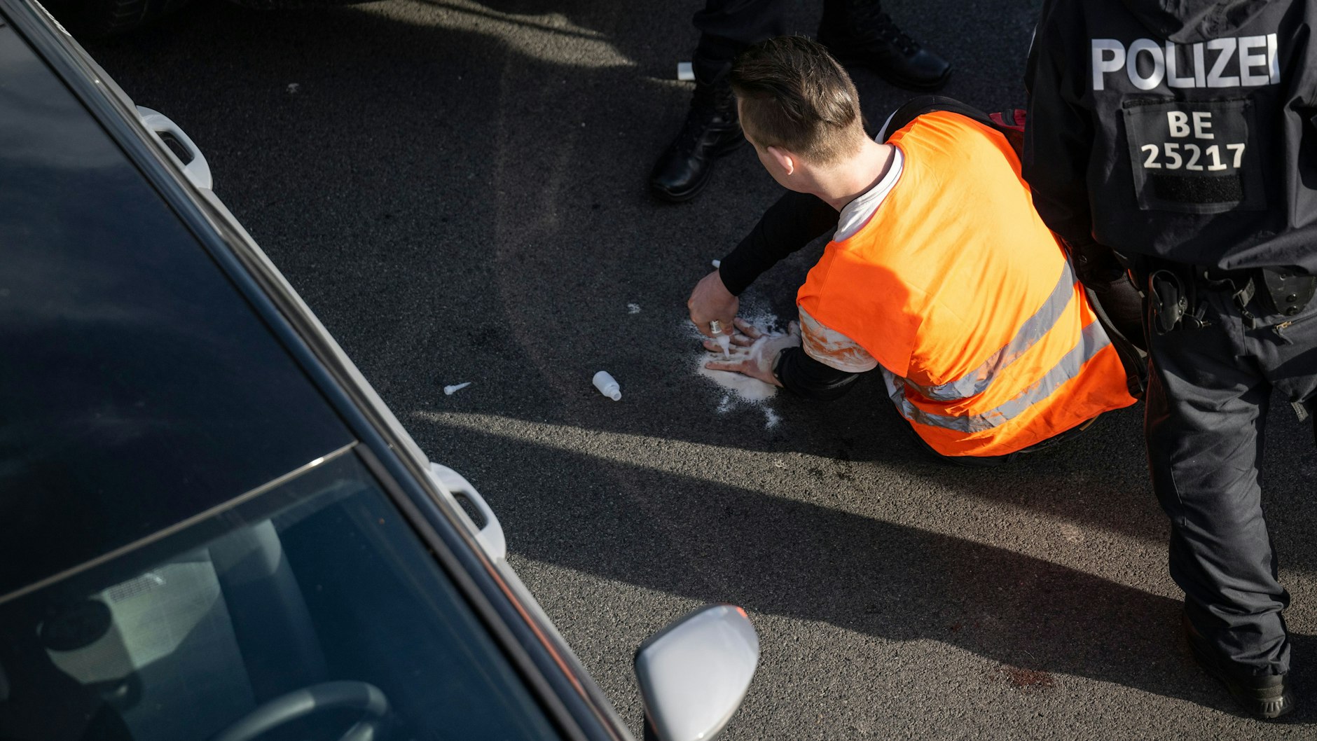 Ein Aktivist klebt sich auf der A100 fest.