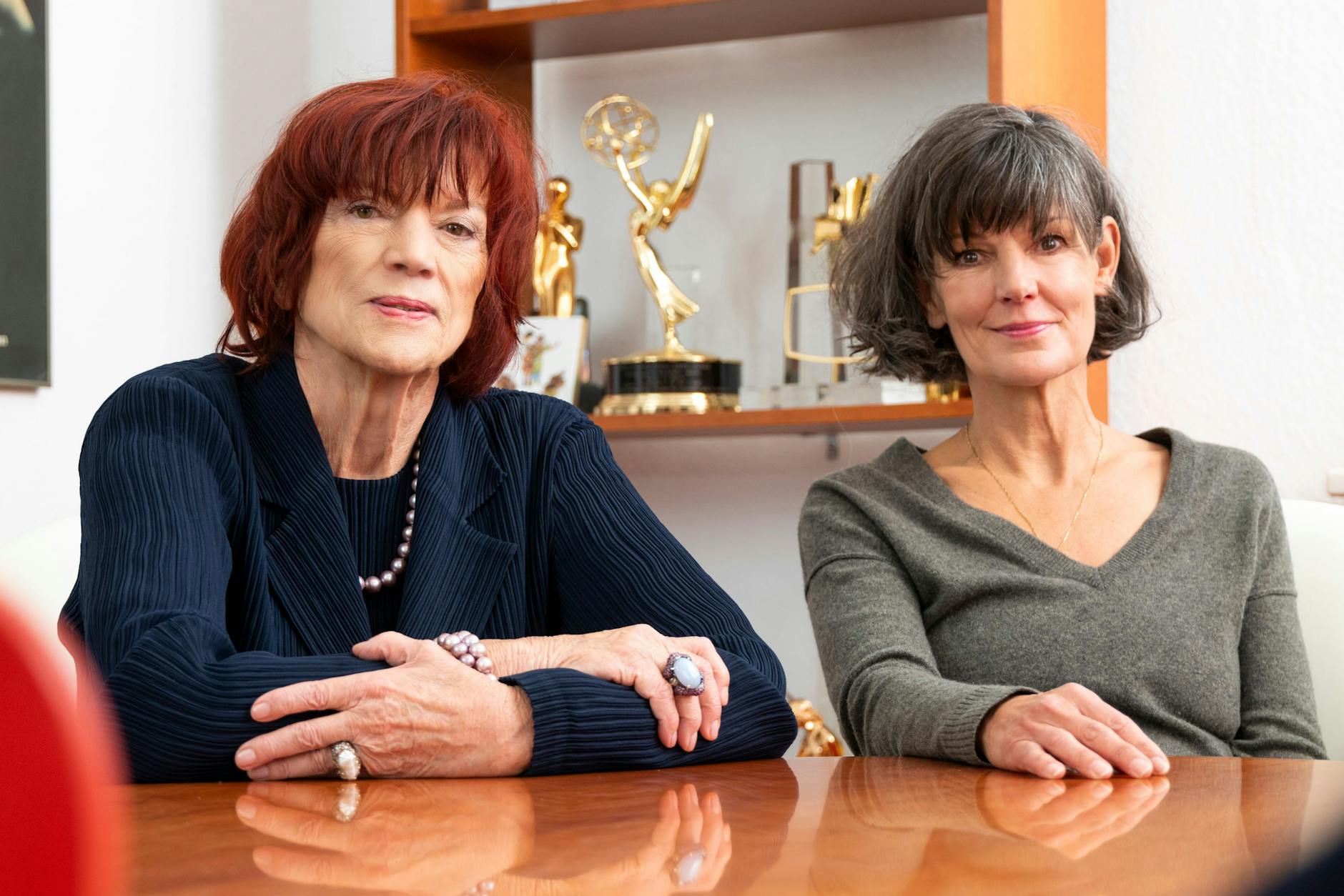 Mutter und Tochter vor einem Regal voller internationaler Auszeichnungen für ihre Produktionen.