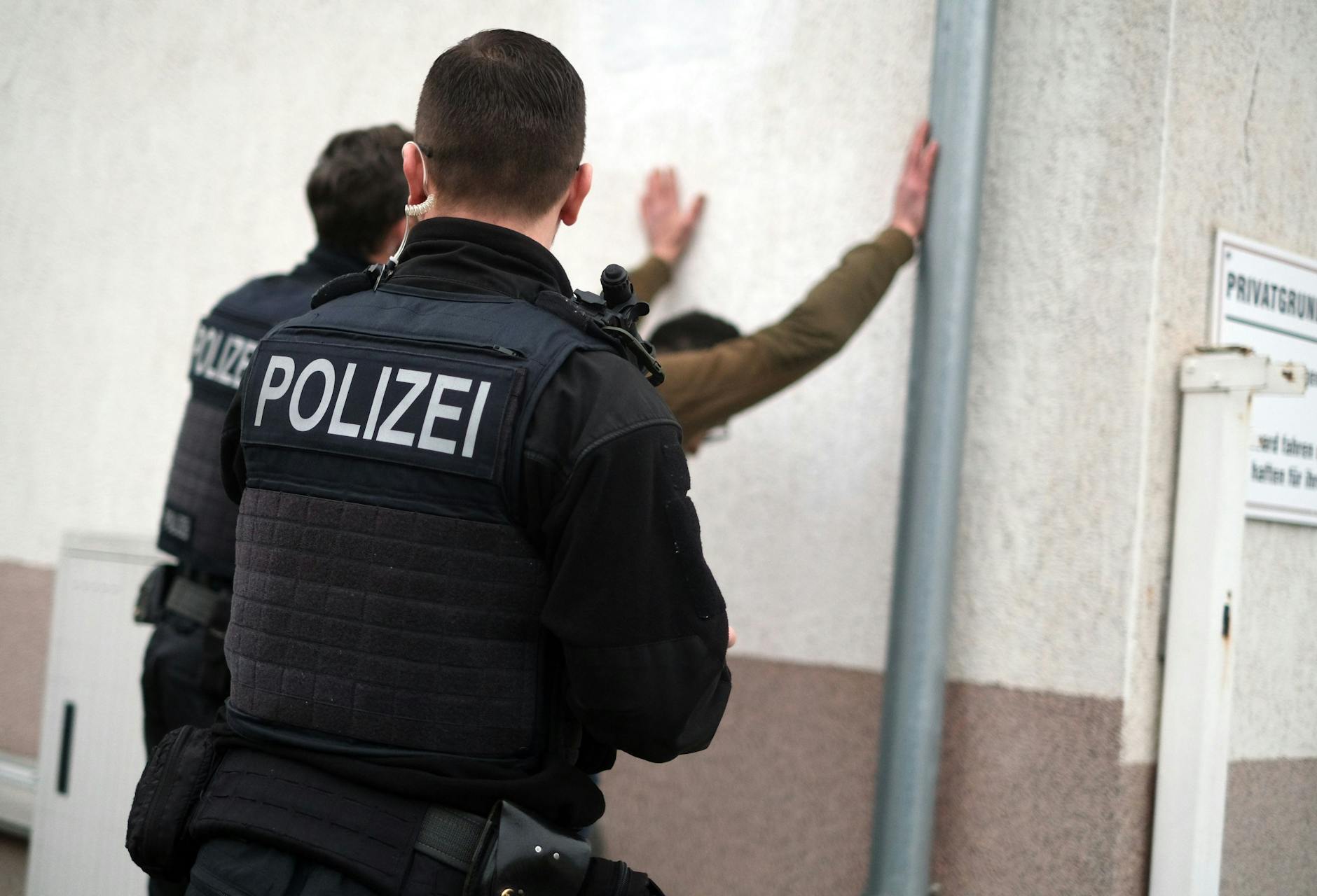 Die Polizisten durchsuchen in Brieskow-Finkenheerd einen mutmaßlichen Schleuser.