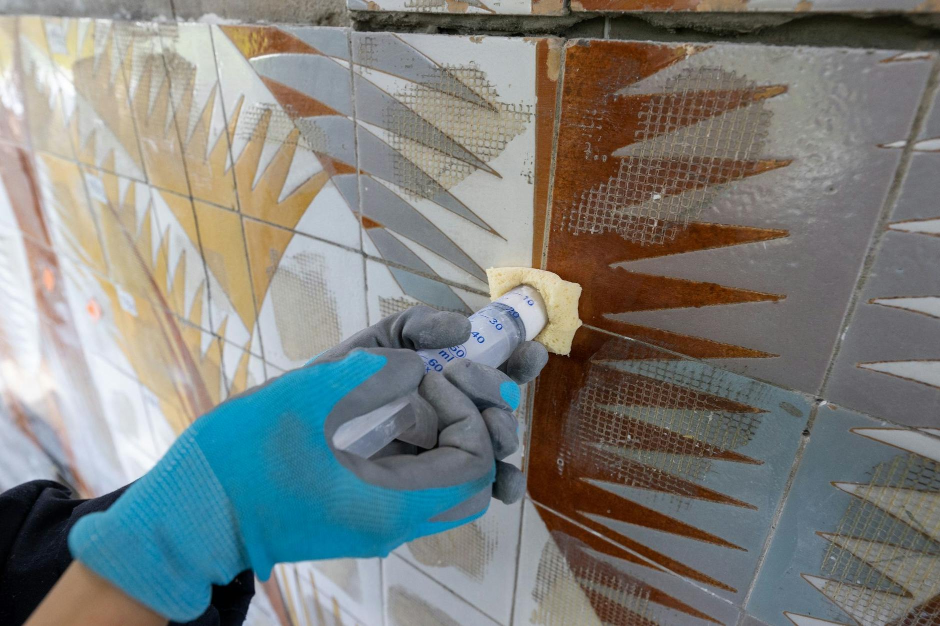 ARCHIV - Eine Restauratorin arbeitet an einem Plattenbau in Halle/Saale an der Restaurierung eines Großmosaiks des spanischen Künstlers Josep Renau (1907-1982).