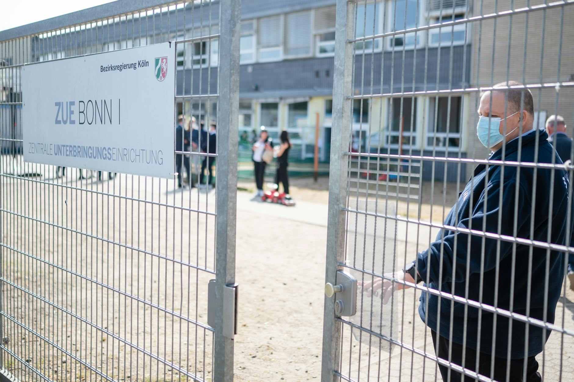 Ein Sicherheitsmitarbeiter schließt das Tor zur zentralen Unterbringungseinrichtung für Flüchtlinge.