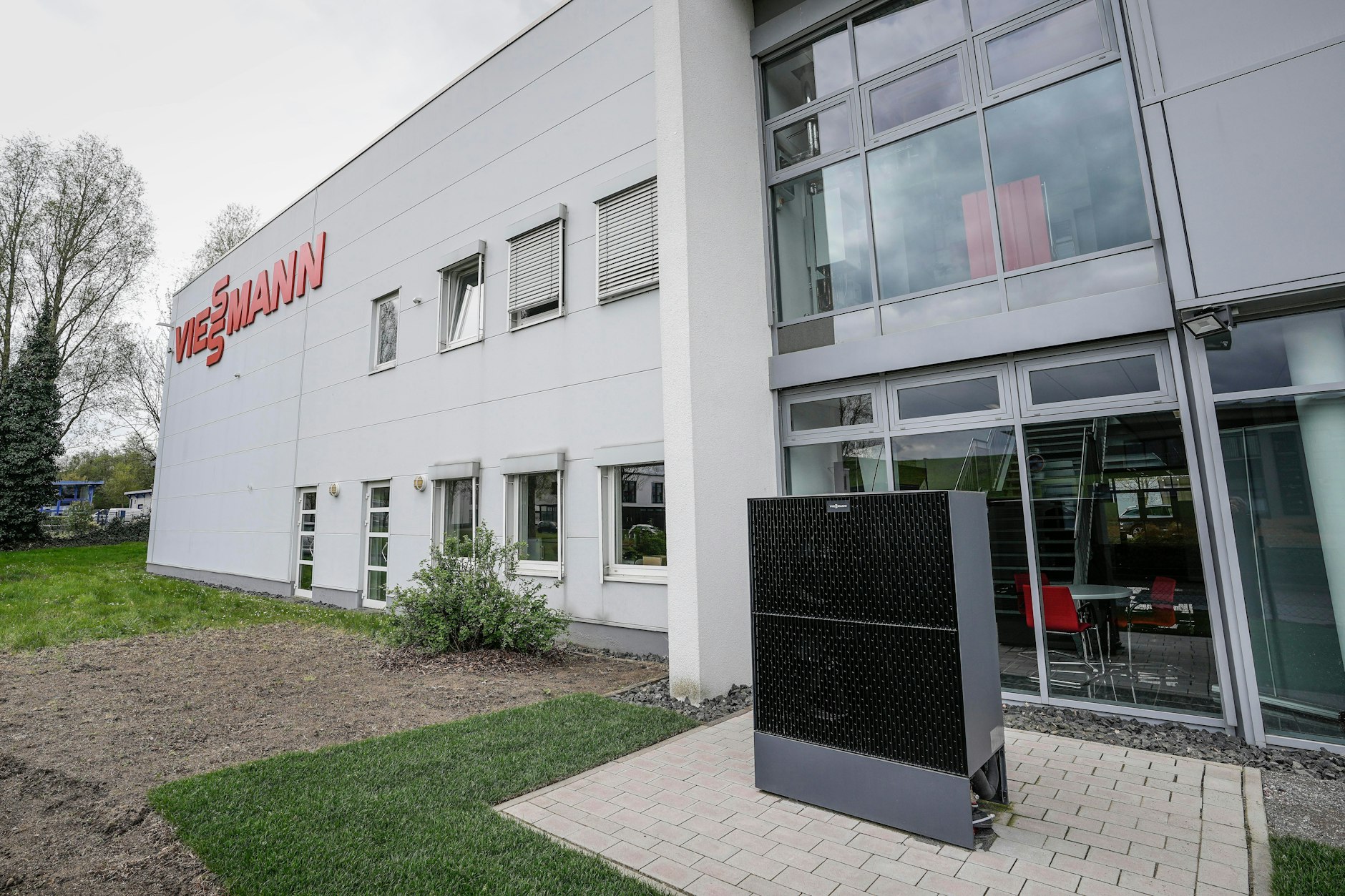 Eine Wärmepumpe steht vor einer Viessmann-Niederlassung. Das Familienunternehmen überraschte mit dem Verkauf seiner Wärmepumpen-Sparte.