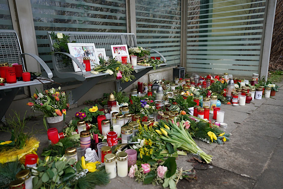 Schleswig-Holstein, Brokstedt: Kerzen und Blumen stehen und liegen im Bahnhof Brokstedt in einem Wartehäuschen.