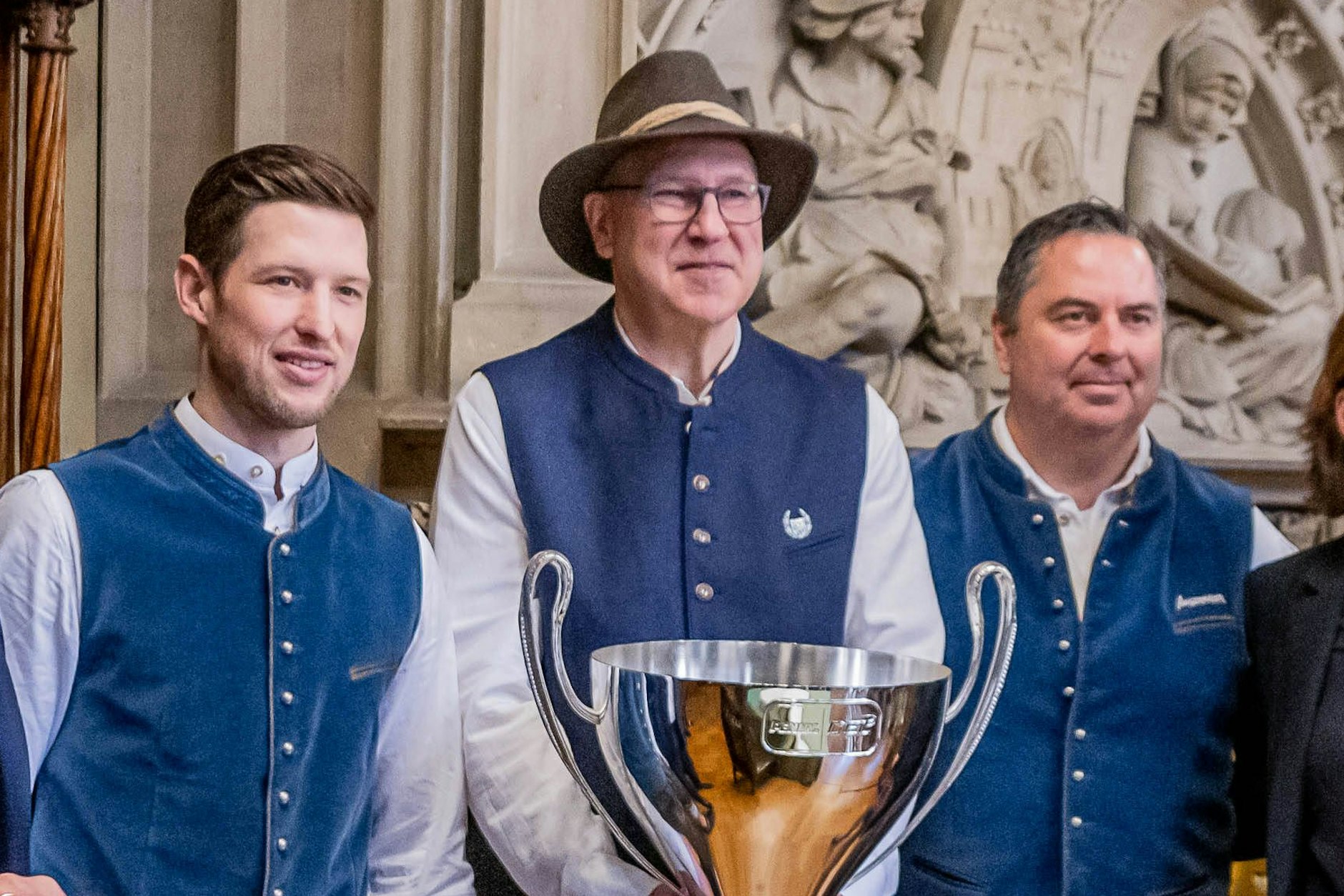 Don Jackson in der Bayern-Tracht mit seinem neunten Meisterpokal. Links: Münchens Kapitän Patrick Hager, rechts Manager Christian Winkler.