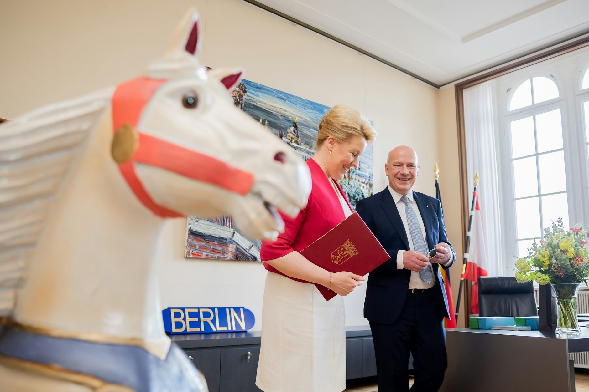Amtsübergabe im Roten Rathaus: der neue Regierende Bürgermeister von Berlin Kai Wegner (CDU) mit seiner SPD-Amtsvorgängerin Franziska Giffey (SPD) und einem Schaukelpferd
