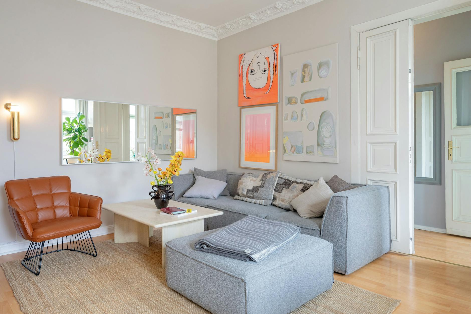 Design und Kunst geben sich ein Stelldichein: Die pillenförmige Messing-Wandleuchte links kommt von DCW Éditions, über dem Sofa ein Farbverlauf der Münchnerin Alina Birkner.