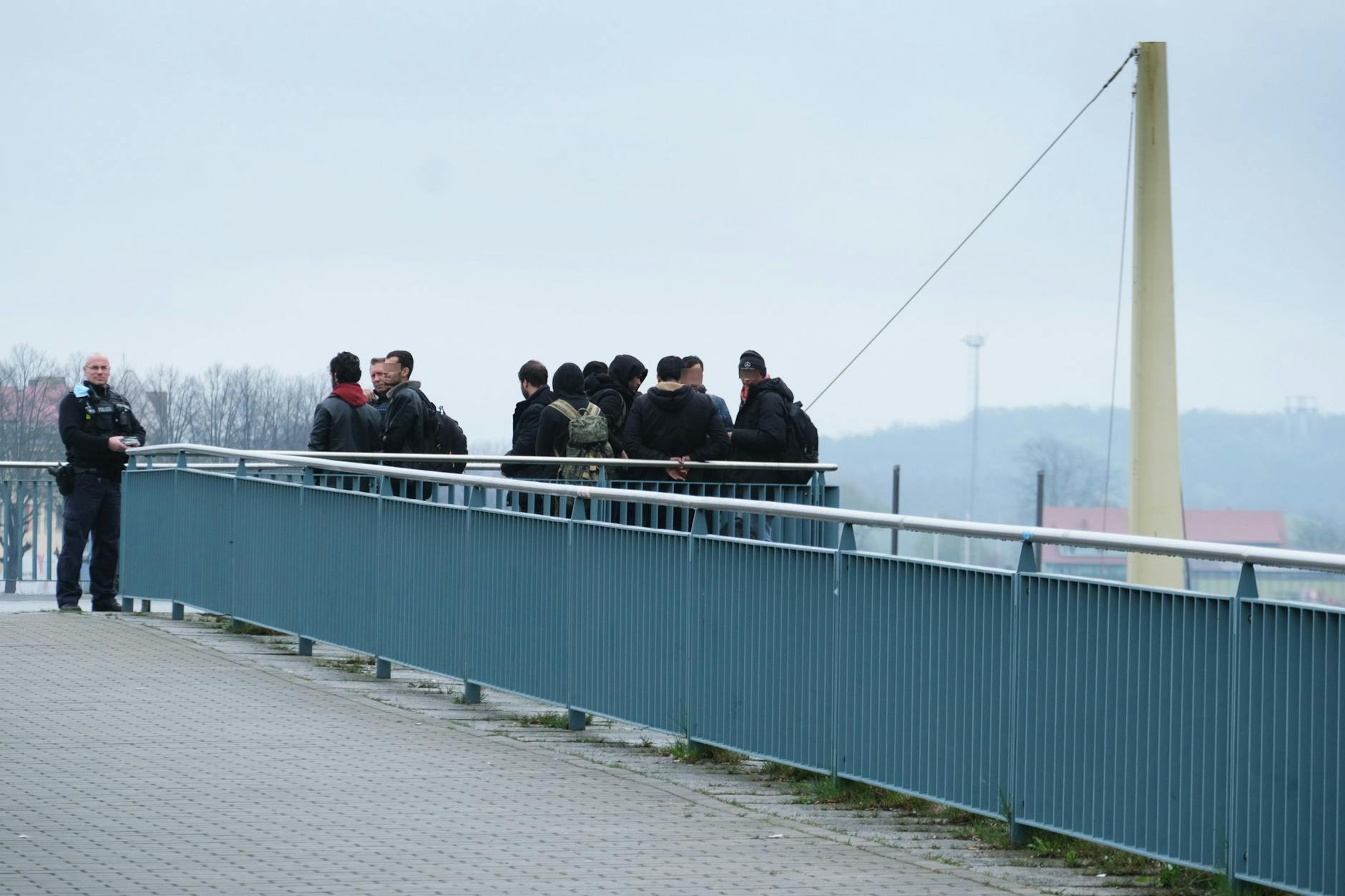 Auf der Stadtbrücke, die Frankfurt (Oder) mit Slubice verbindet, halten Polizisten eine Gruppe Migranten fest.