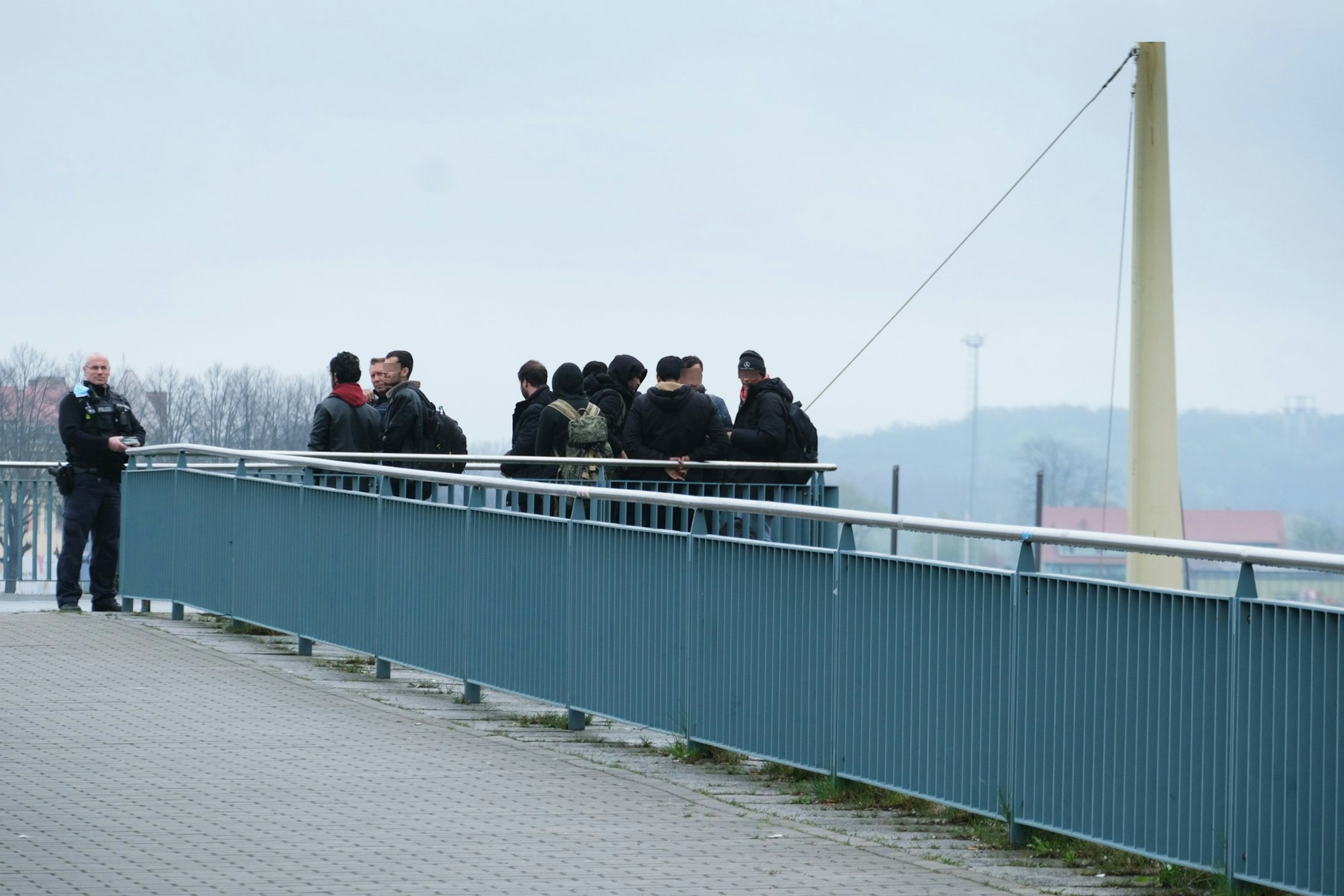 Auf der Stadtbrücke, die Frankfurt (Oder) mit Slubice verbindet, halten Polizisten eine Gruppe Migranten fest.