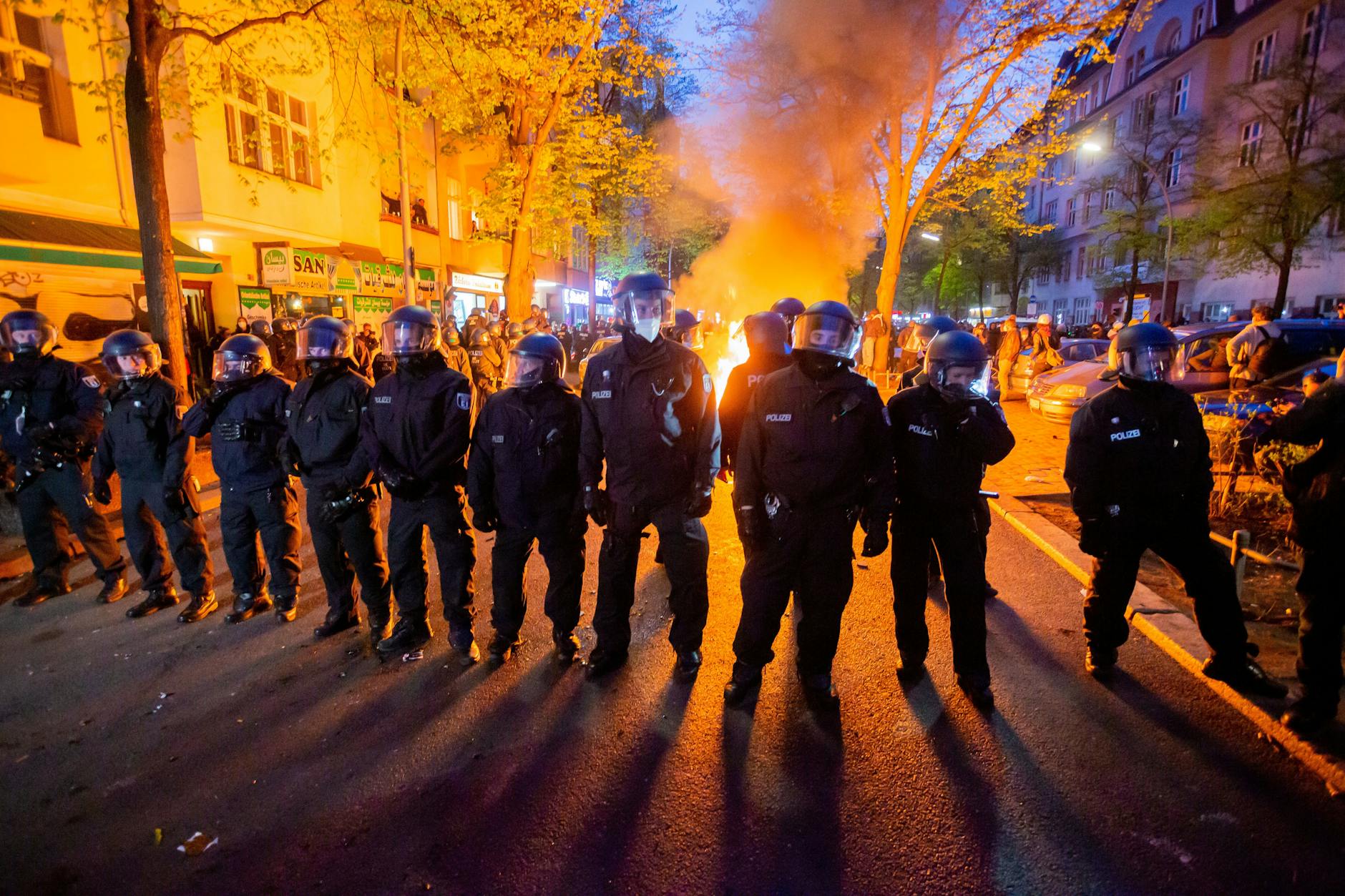 Polizisten stehen am 1. Mai 2021 vor einem Feuer auf der Straße am Rande der Demonstration linker und linksradikaler Gruppen unter dem Motto „Demonstration zum revolutionären 1. Mai“.