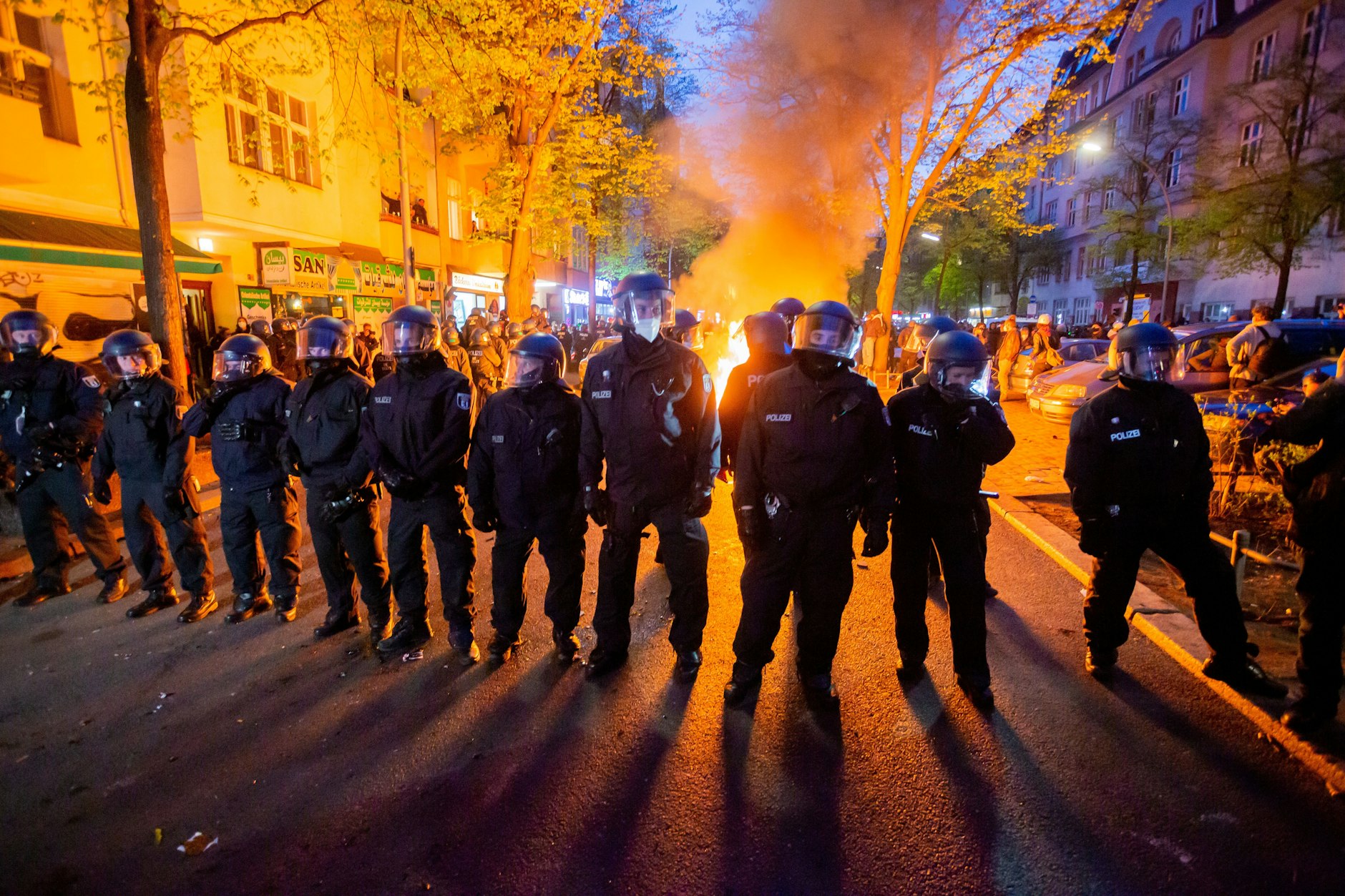 Polizisten stehen am 1. Mai 2021 vor einem Feuer auf der Straße am Rande der Demonstration linker und linksradikaler Gruppen unter dem Motto „Demonstration zum revolutionären 1. Mai“.