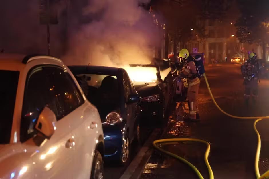 Die Chaoten zündeten mehrere Autos an, die Feuerwehr löscht.