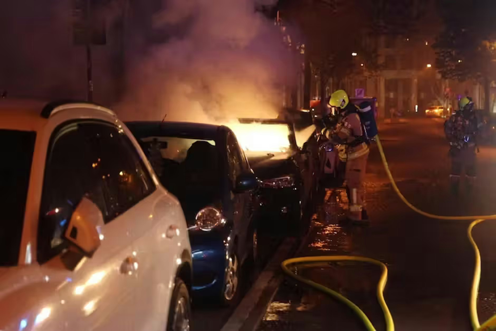 Die Chaoten zündeten mehrere Autos an, die Feuerwehr löscht.