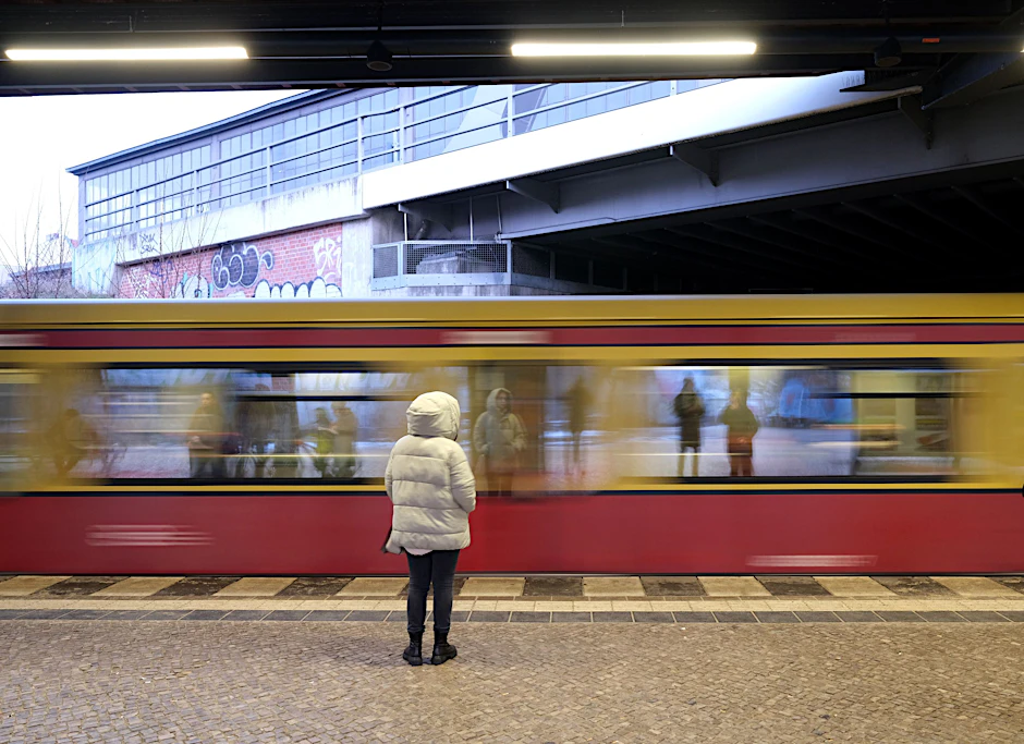 Eine Frau wartet auf eine einfahrende S-Bahn.&nbsp;