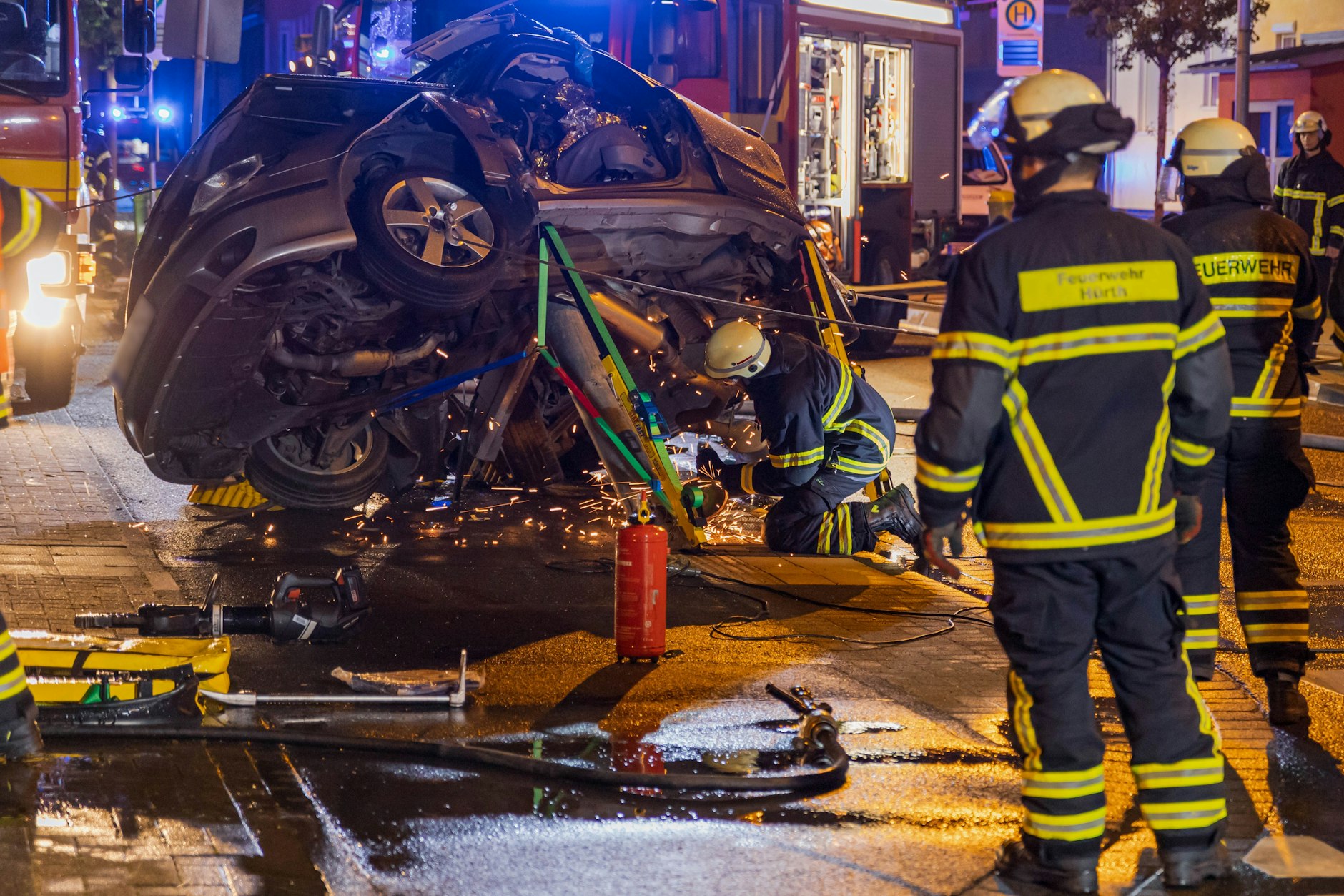 In Hürth bei Köln bergen Einsatzkräfte ein völlig zerstörtes Autowrack. Nach einem schweren Unfall ist ein Autofahrer geflohen und hat einen ums Leben gekommenen 44-jährigen Beifahrer und einen schwer verletzten Jungen zurückgelassen.