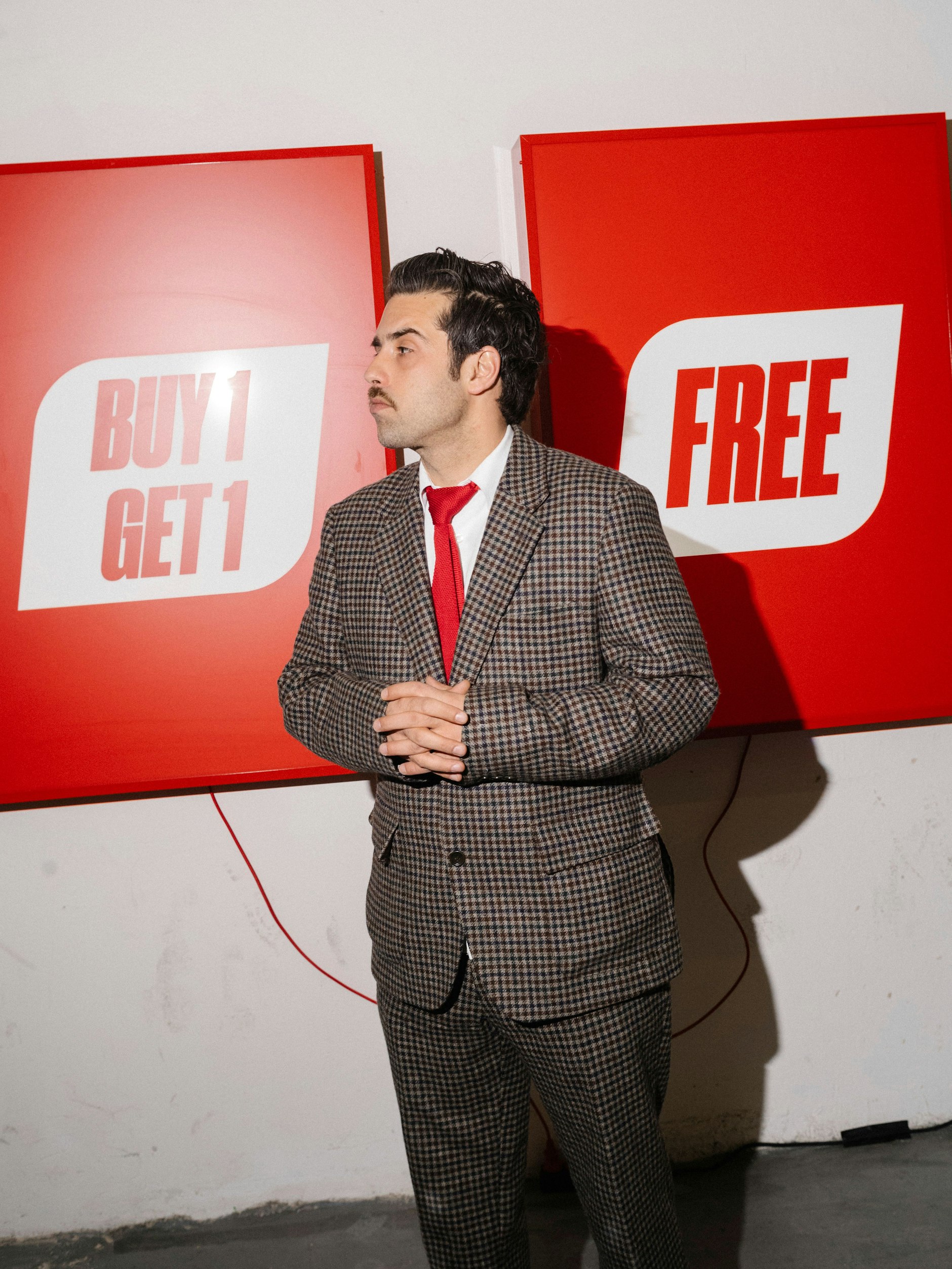 Der Künstler Joachim Bosse vor Kunstwerken seiner Ausstellung „For Sale“