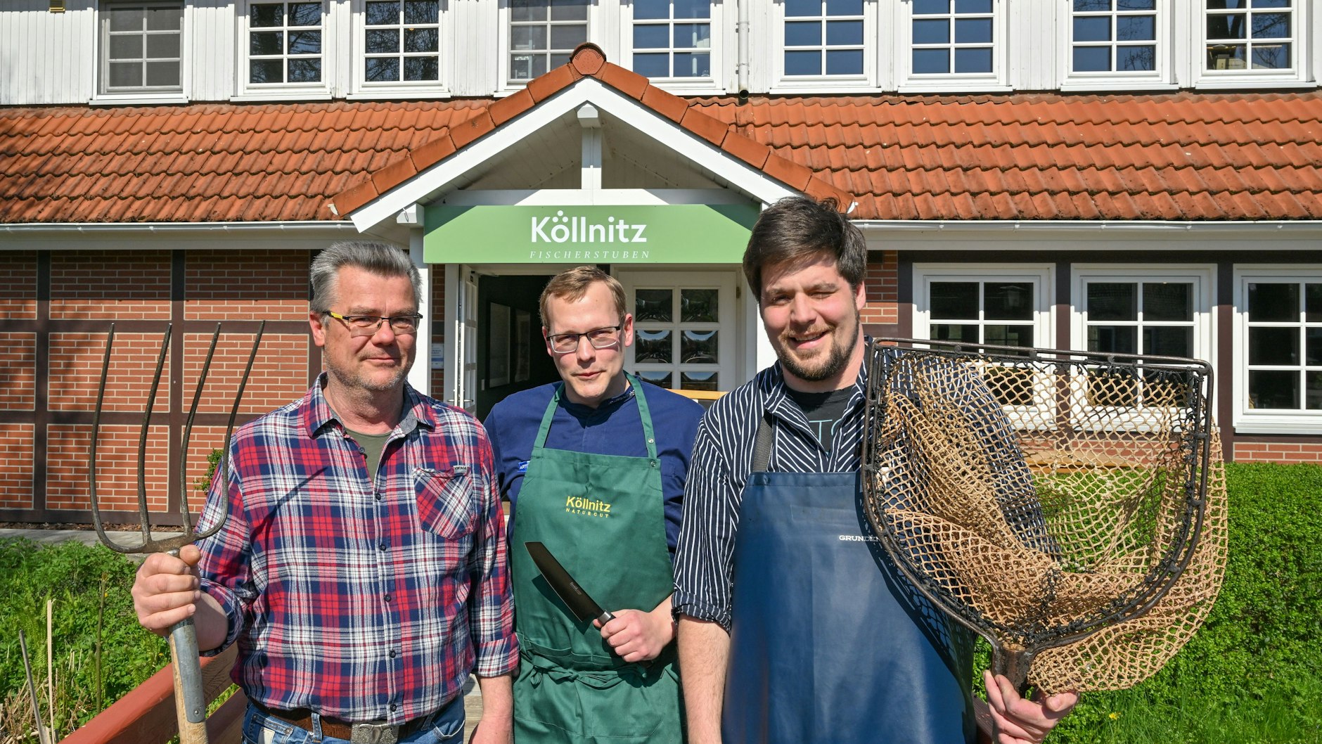Landwirt Jan-Peter Vogel (v.l.), Küchenchef Stefan Ziegenhagen und Fischer Frederik Buhrke vom Naturgut Köllnitz am Großen Schauener See stehen vor dem Restaurant Köllnitzer Fischerstuben.