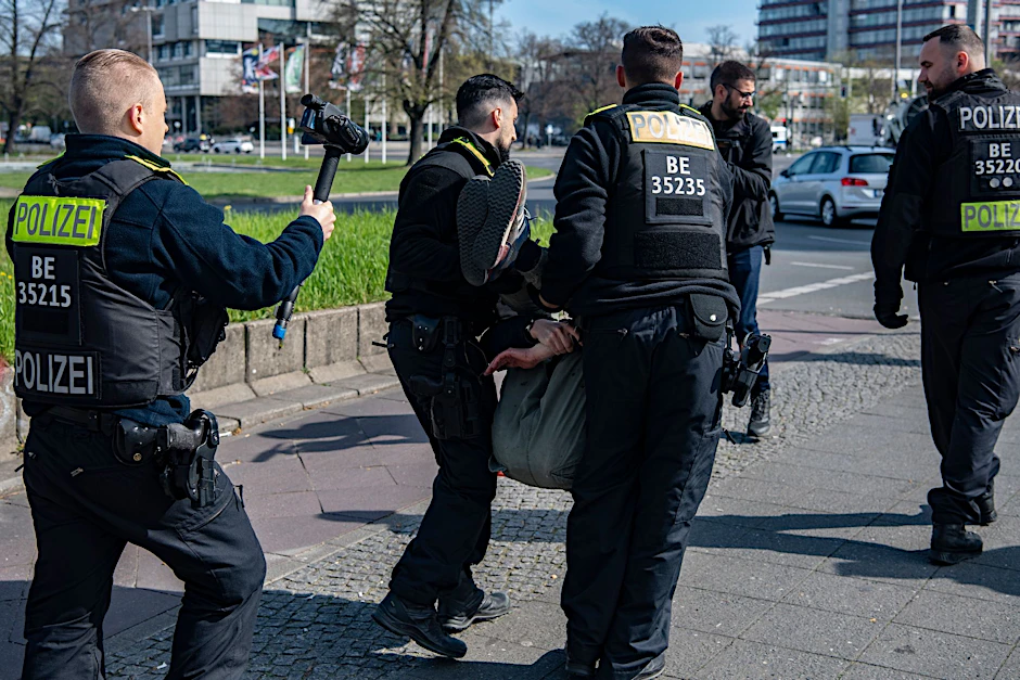 Polizeibeamte tragen am Ernst-Reuter-Platz einen Aktivisten der Letzten Generation für Klimaschutz von der Straße.  