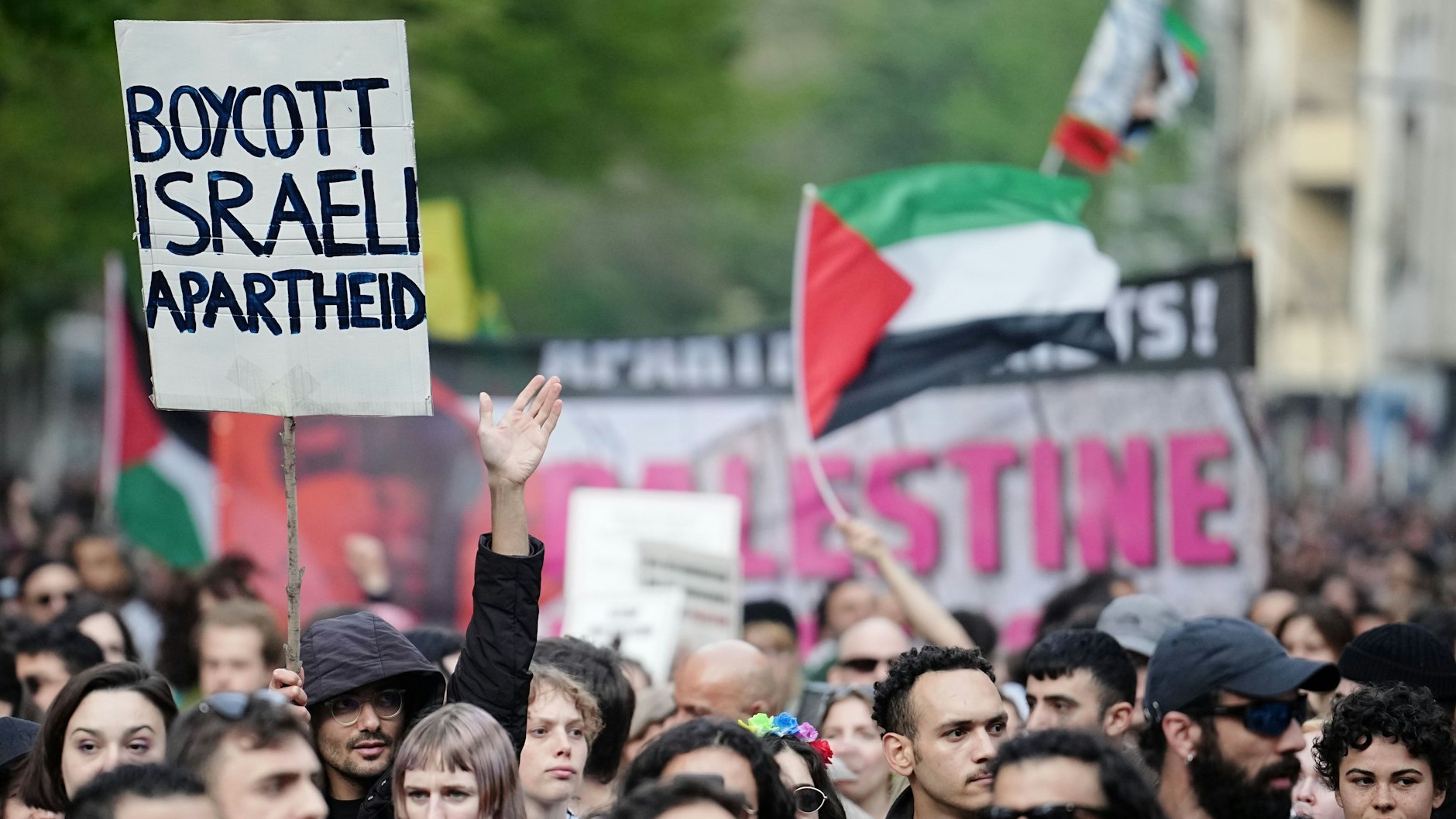 Demonstranten halten ein Plakat mit der Aufschrift „Boycott Israeli Apartheid“ hoch. 