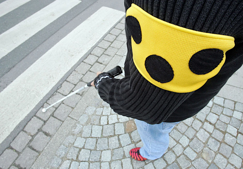 ARCHIV - Ein blinder Mann geht mit seinem weißen Taststock und einer Armbinde mit drei Punkten über eine Straße in Hannover.  