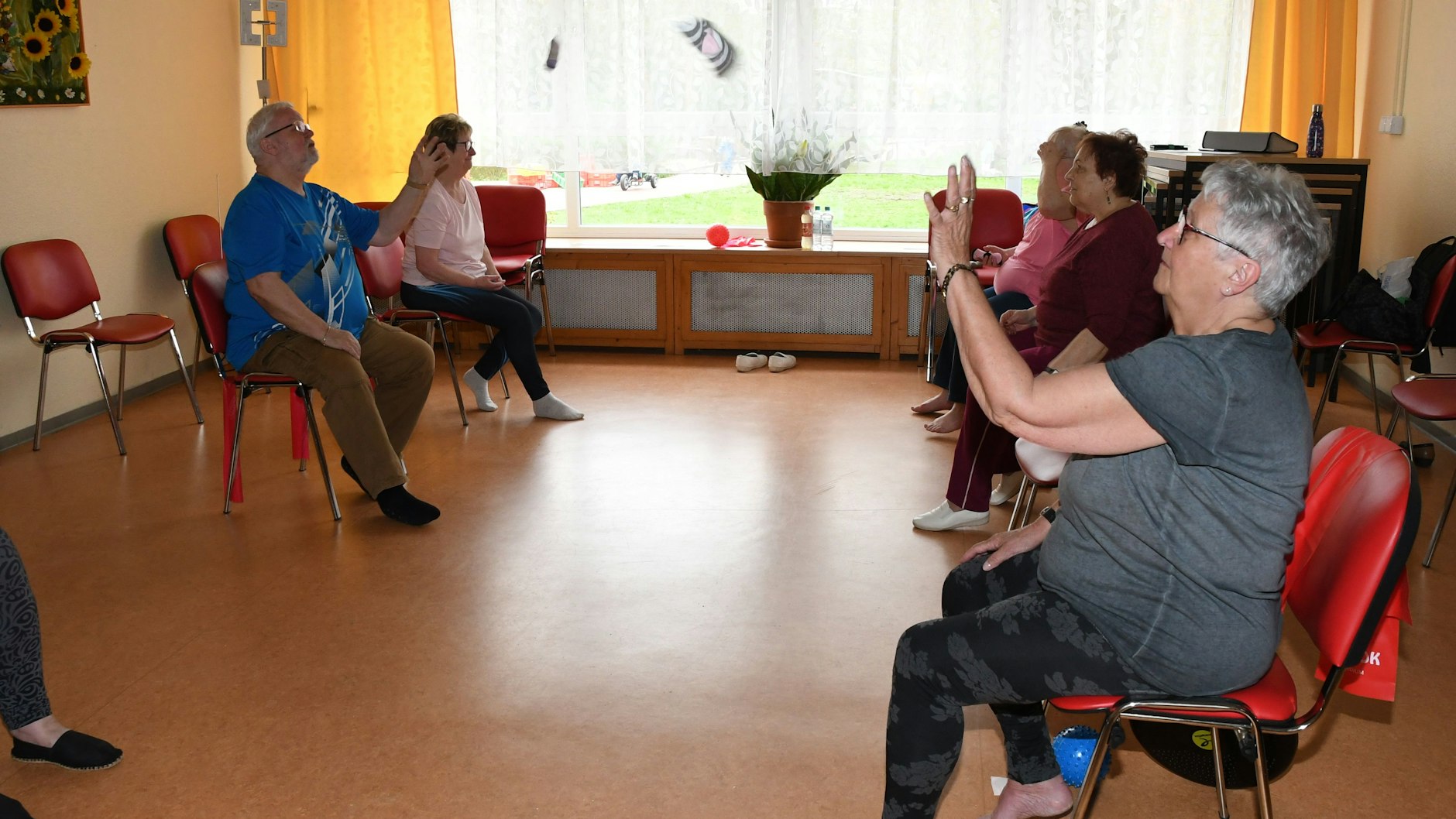 Stuhlgymnastik mit Linda Bölke im Nachbarschaftshaus KIEK IN. Rüstige Seniorensport-Gruppe lässt Babysöckchen fliegen 