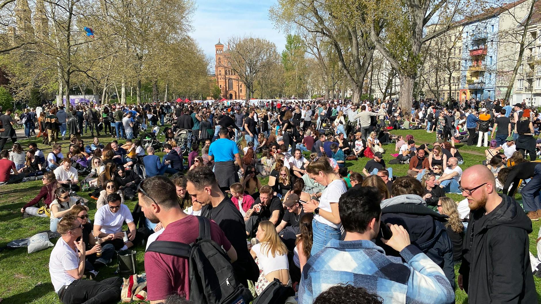  Hunderte von Menschen versammeln sich im Sonnenschein auf dem Mariannenplatz in Kreuzberg.