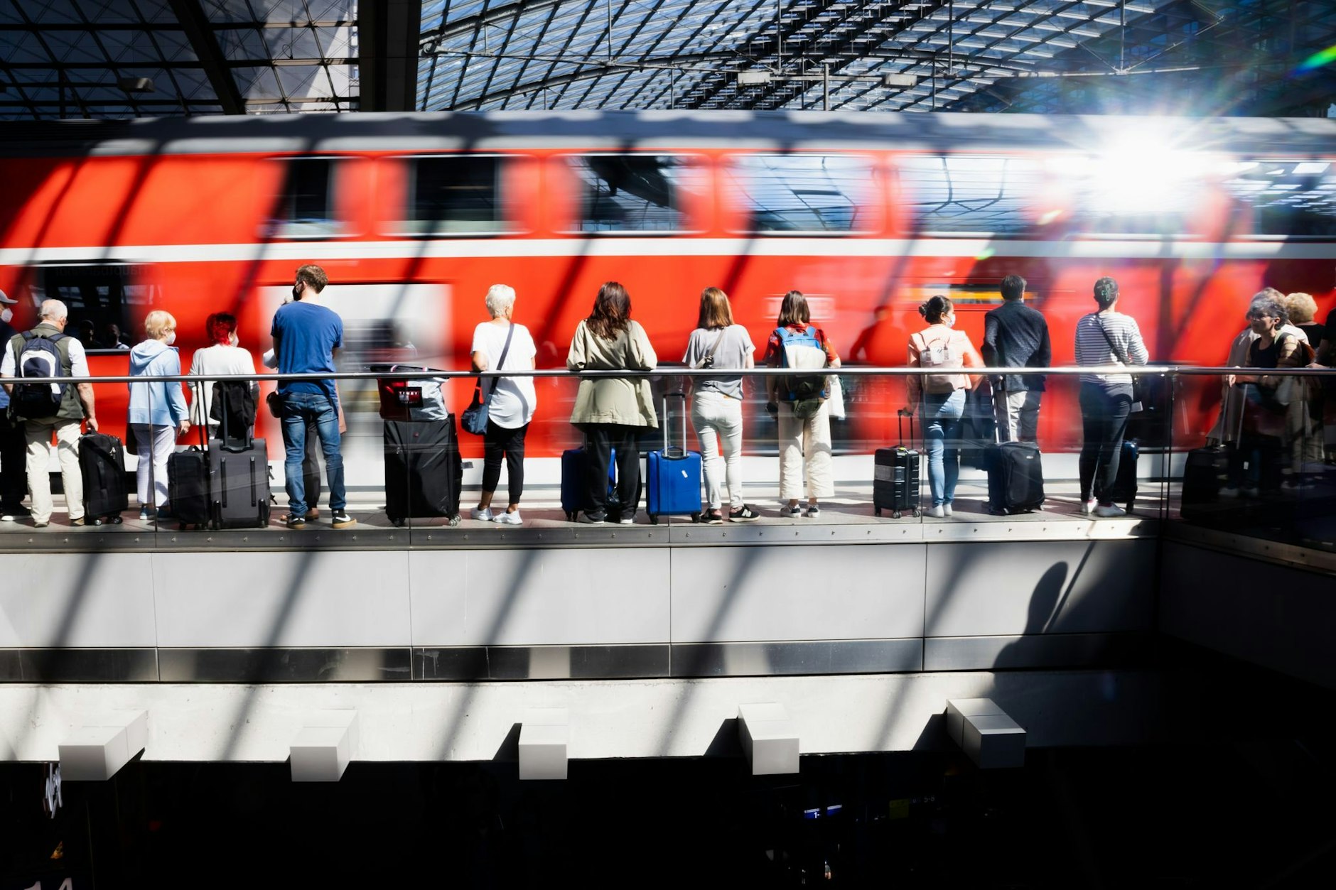 Fahrgäste warten am Berliner Hauptbahnhof auf die Einfahrt eines Regionalexpresses.