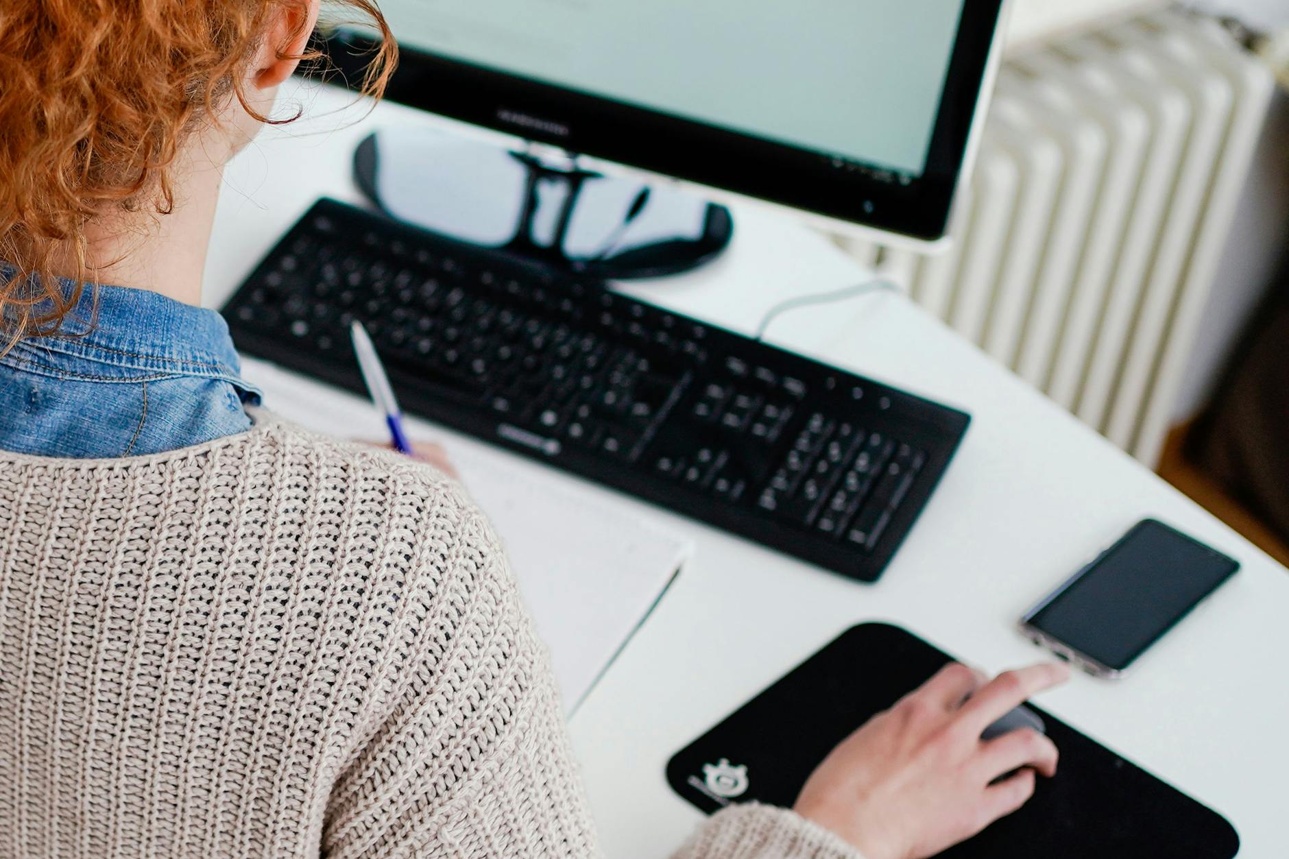 Windows PC und iPhone liegen auf einem Stehtisch.