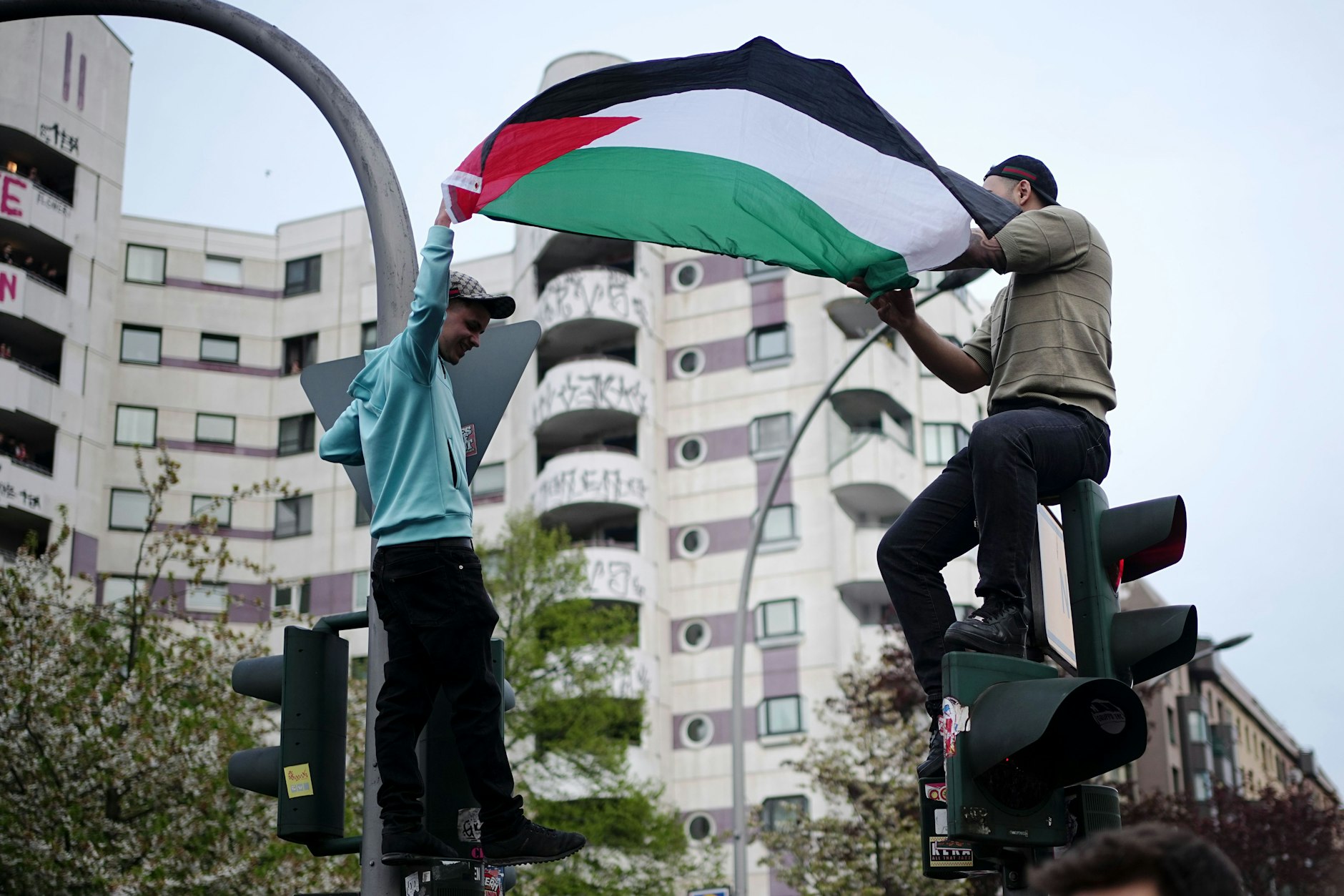 Am Kottbusser Tor halten zwei Männer eine Palästinenser-Flagge hoch. Unter dem Motto „Revolutionärer 1. Mai“ hatten linke und linksradikale Gruppen zu einer Demonstration am Tag der Arbeit aufgerufen.