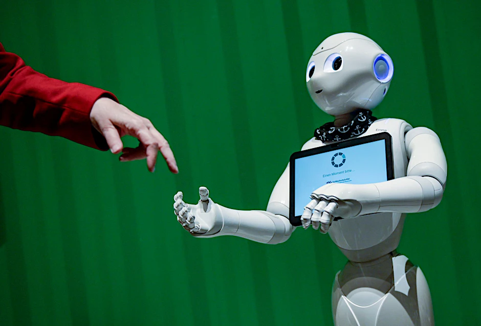 ARCHIV - Ein Roboter interagiert bei der Veranstaltung im Hammerbrooklyn Digital Campus in Hamburg mit einer Frau.  
