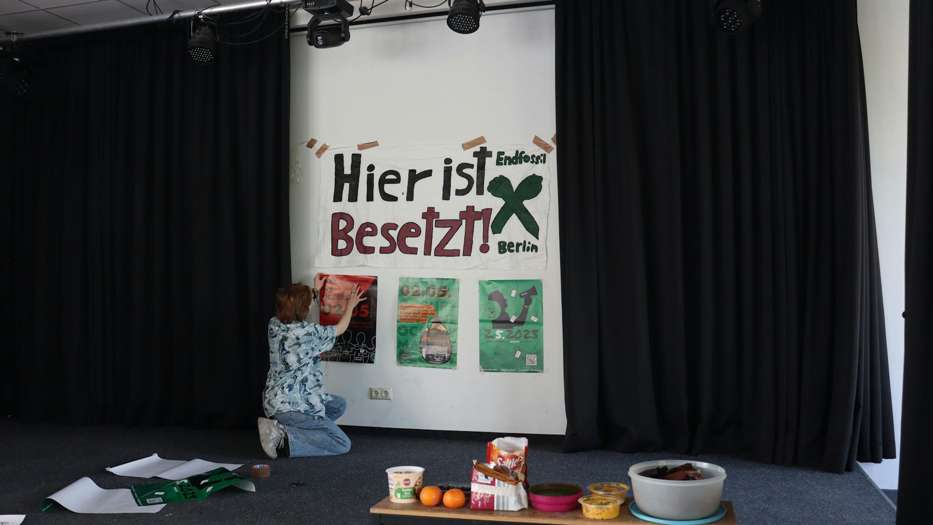 Eine Schülerin hängt ein Plakat an eine Wand des Berliner Melanchthon-Gymnasiums.