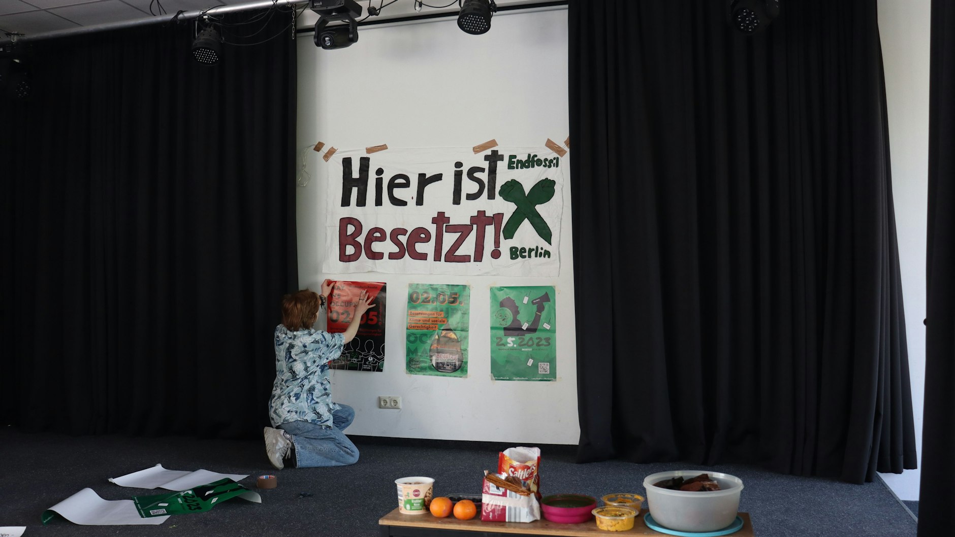 Eine Schülerin hängt ein Plakat an eine Wand des Berliner Melanchthon-Gymnasiums.