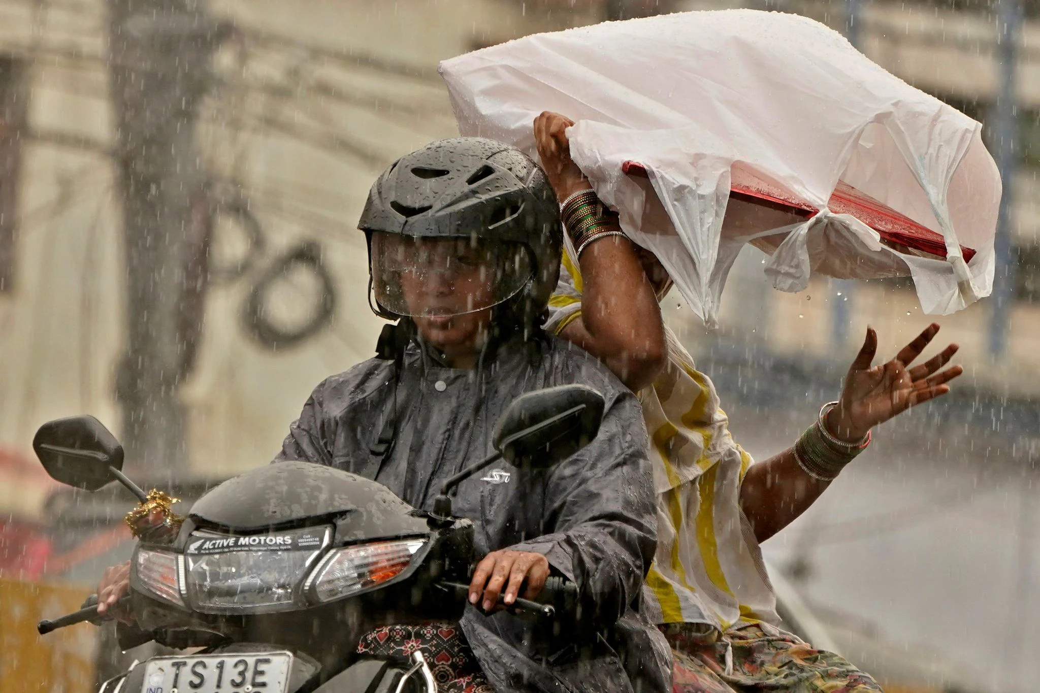 Zwei Frauen fahren in Hyderabad im Süden Indiens durch den Monsunregen. Die indische Regenzeit dauert in der Regel bis in den Herbst an.  