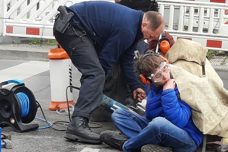 Ein Aktivist wird aus der Straße geflext.