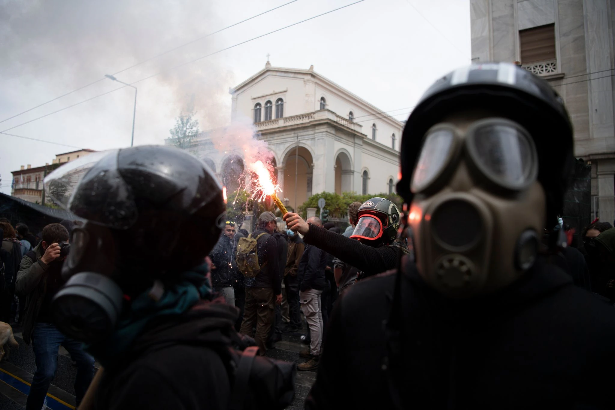 dpatopbilder - Demonstranten tragen Gasmasken und halten Pyro-Fackeln während einer Demonstration am Tag der Arbeit in Athen.  