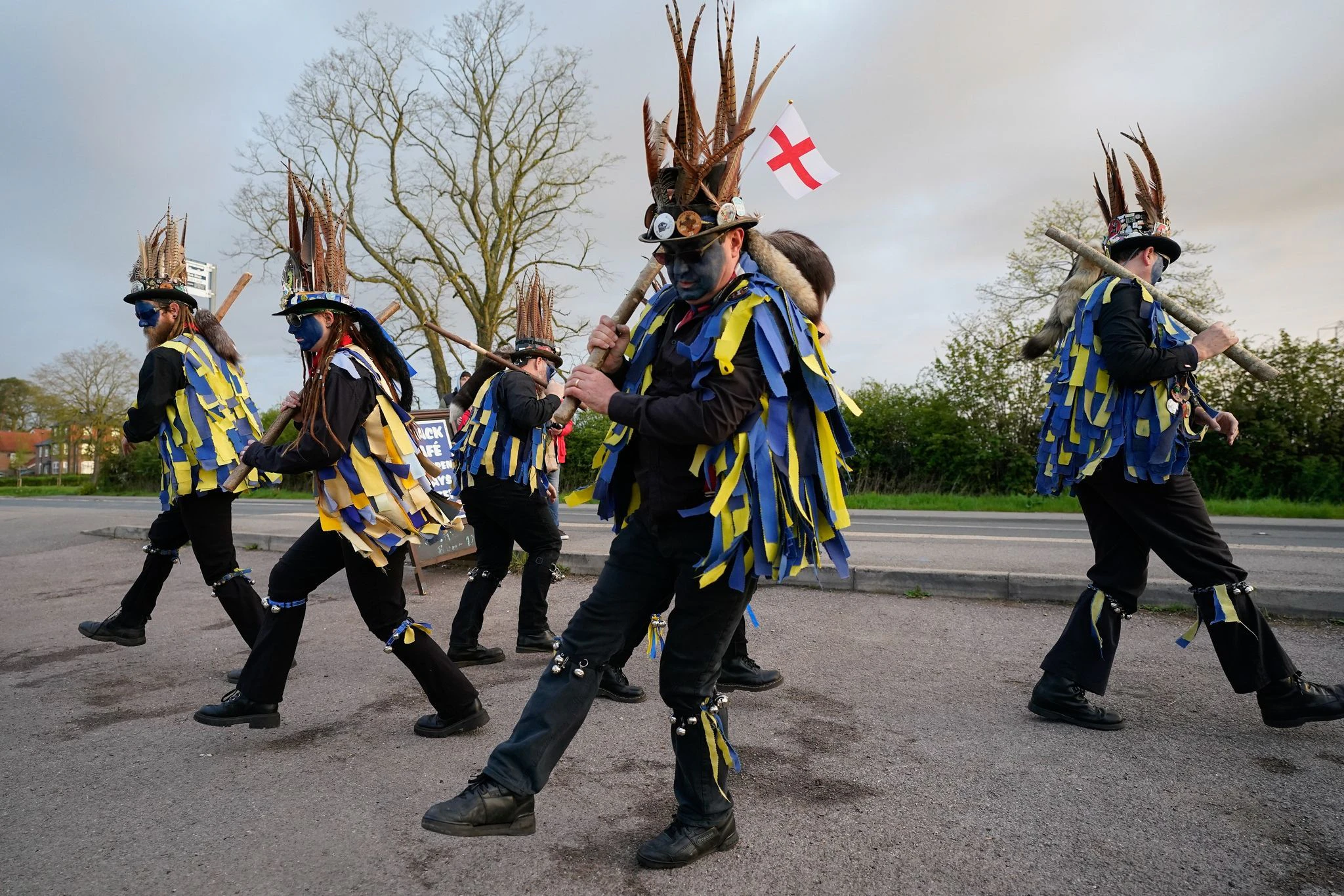 Mitglieder der Hook Eagle Morris Men tanzen vor dem Shack Cafe in der Nähe von Hook in Hampshire in der Morgendämmerung des 1. Mai. Morris Dancing ist eine Form des englischen Volkstanzes, bei der hier die Tänzer in ihrer Choreographie Glockenpolster an den Schienbeinen tragen.  