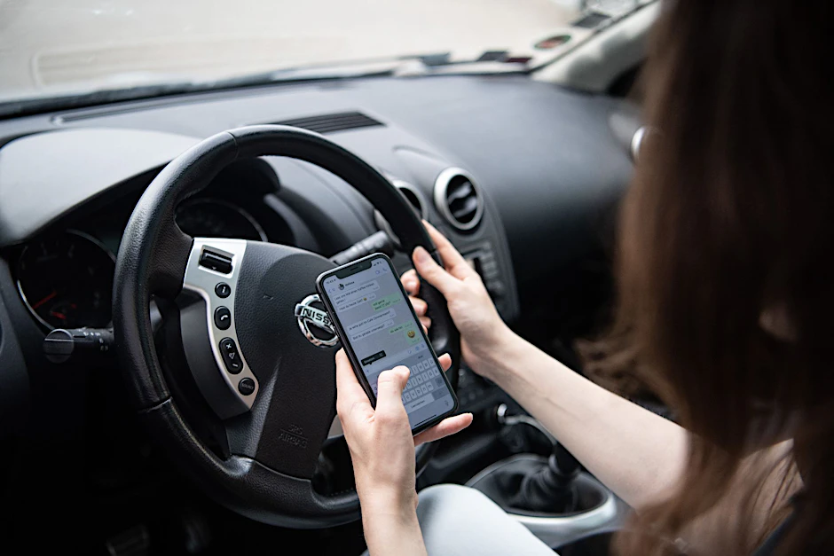 ARCHIV - Am Handy sein, während man Auto fährt, ist verboten.  