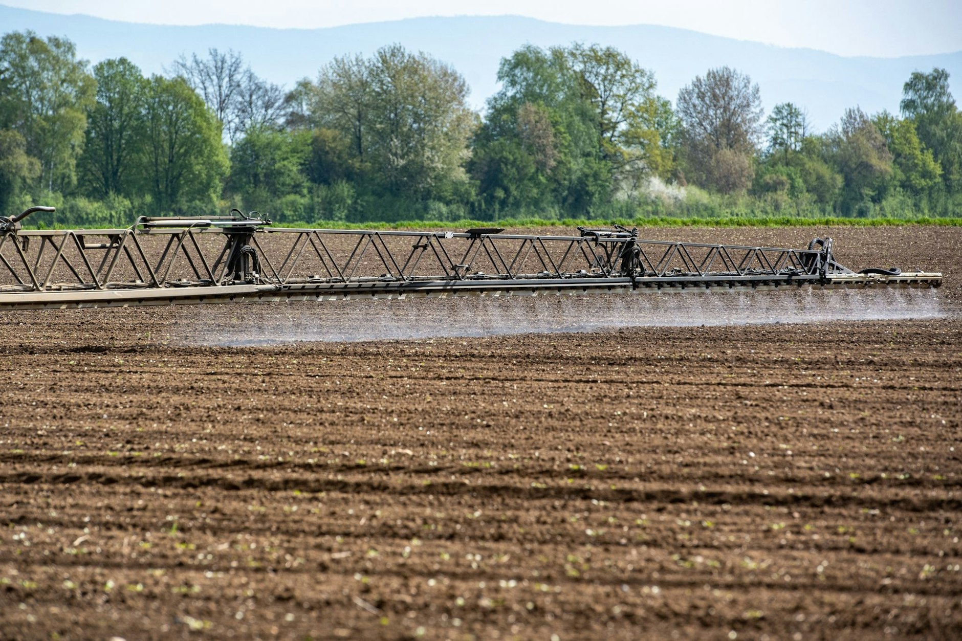ARCHIV - Ein Traktor bringt auf einem Acker im bayerischen Straubing Pflanzenschutzmittel aus.