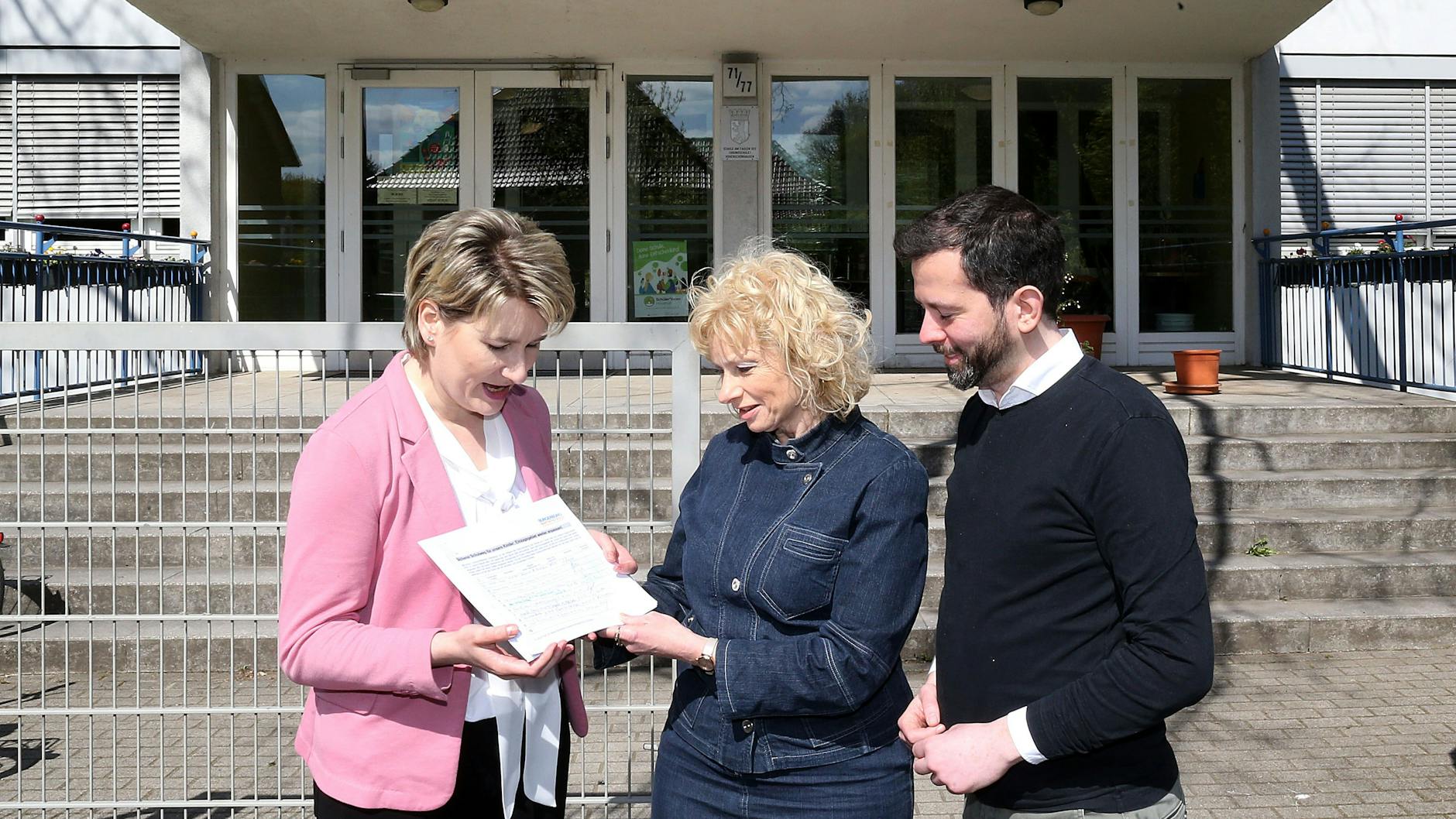 Elternvertreterin Dörthe Ploß (l.) und der Abgeordnete Martin Pätzold übergeben vor der Grundschule am Faulen See die Unterschriften an die neue Lichtenberger Stadträtin Catrin Gocksch. Sie will sich des Schulweg-Problems annehmen.