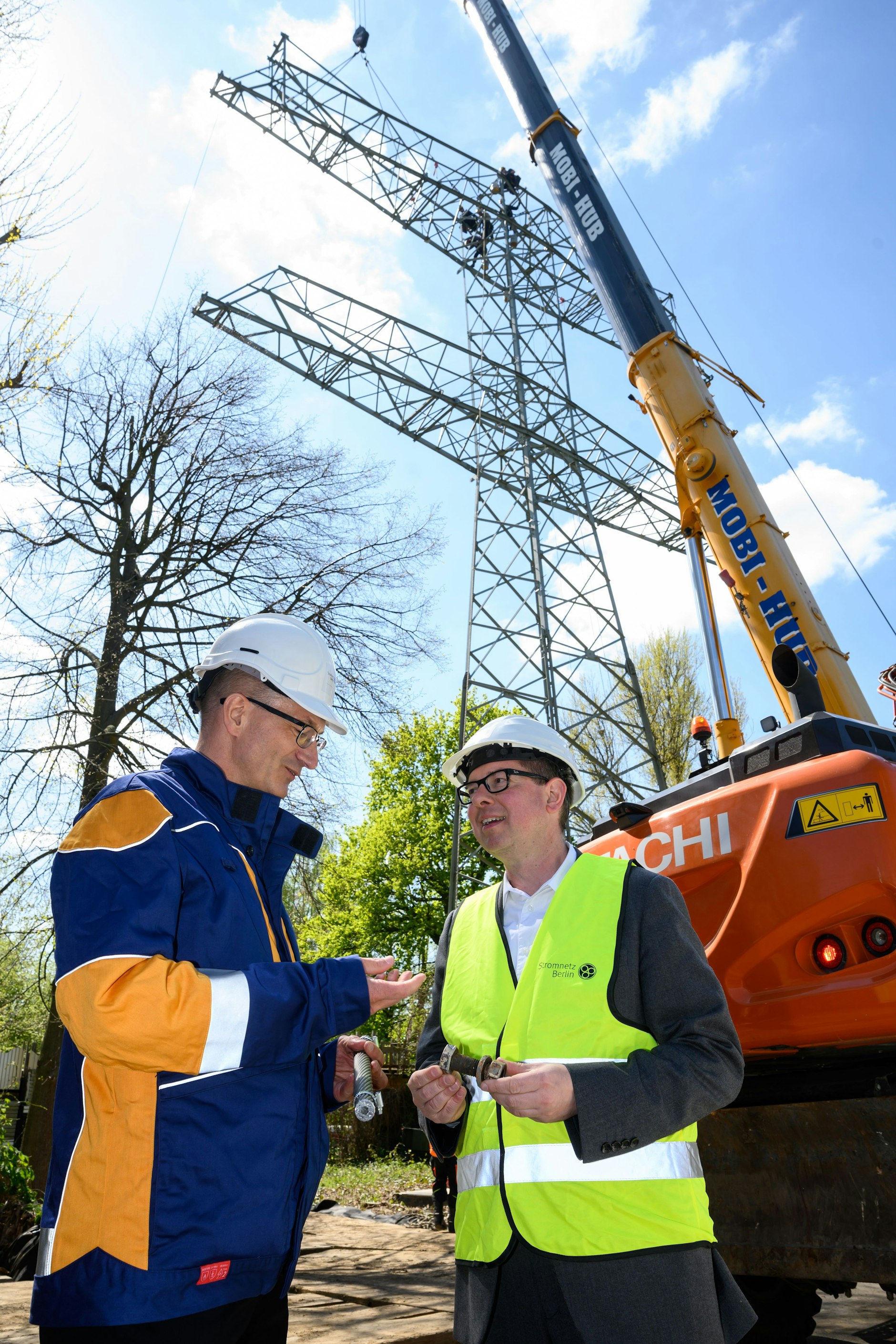 Nr. 5 stirbt ... Ein Kran hebt die ersten Teile des Masts 5 ab, der zur stillgelegten Freileitung vom Kraftwerk  Klingenberg zum Netzknoten Wuhlheide führte. Bürgermeister Oliver Igel (r.) und Stromnetz Berlin-Chef Erik Landeck verfolgten die Aktion.