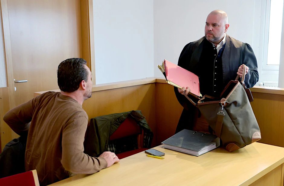 Der wegen Betrug angeklagte Bestattungsunternehmer (l-r) und sein Verteidiger Benjamin Richert im Gericht.  